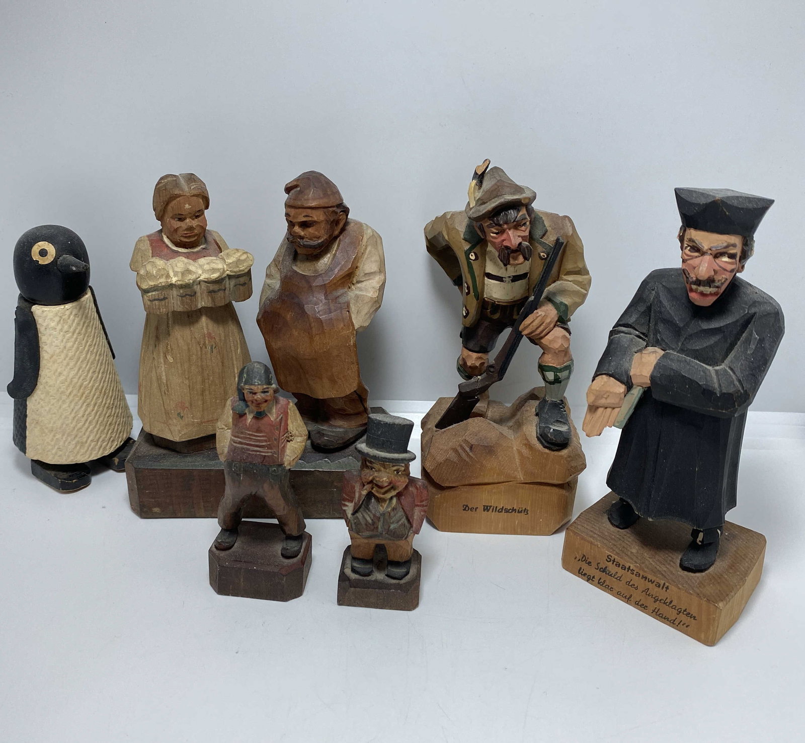 LOT OF 6 CARVED WOOD GERMAN BLACK FOREST ANRI: UNIQUE SCULPTURE LOT PRIEST MARKED "STAATSANWALT DIE SCHULD DES ANGCKLAGTEN LIEGT KLAX AUF DEE HAND!" BARMAID AND BARTENDER. ONE MARKED "MADE IN ITALY". BAVARIAN HUNTER IS 5.5" TALL AND MARKED "DER WI