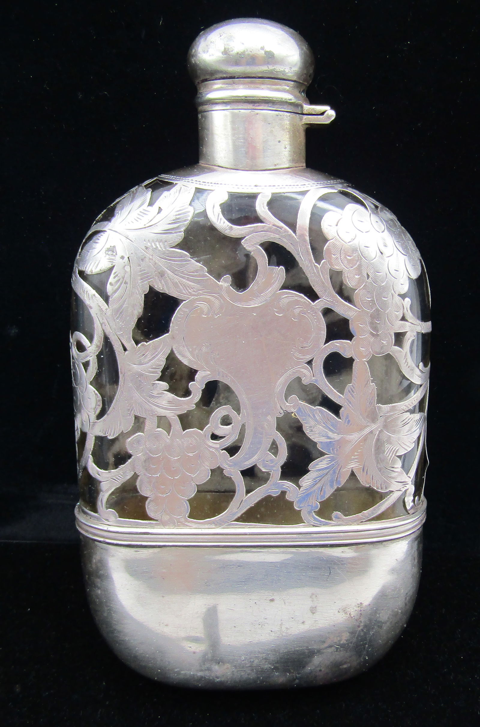 ALVIN 1/2 PINT FLASK STERLING SILVER GLASS OVERLAY: ANTIQUE,100 YEARS OLD, HALLMARKED FOR ALVIN, "STERLING, 4174, 1/2 PINT". STERLING SILVER OVERLAY CRYSTAL FLASK. TOP HALF ENCASED IN LEAVES AND GRAPES. THE BOTTOM HALF HAS A FITTED STERLING DETACHABLE