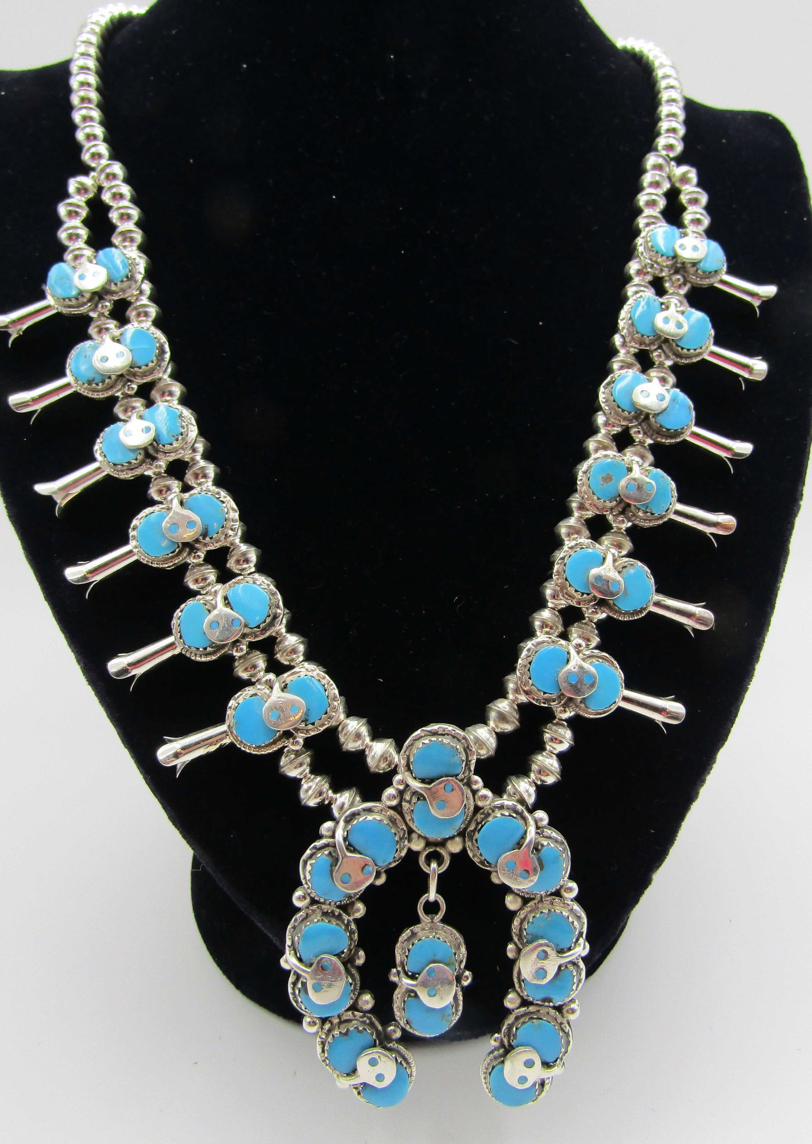 EFFIE C TURQUOISE SQUASH BLOSSOM STERLING SILVER: SNAKE NECKLACE SIGNED "EFFIE C ZUNI STERLING" CALAVAZA SILVER NATIVE AMERICAN SOUTHWEST INDIAN JEWELRY. NAJA MEASURES 2.5" BY 1.75. WEIGHS 102.7 GRAMS. MEASURES 24 INCHES LONG PLUS 2 1/2" DROP. EXCELL