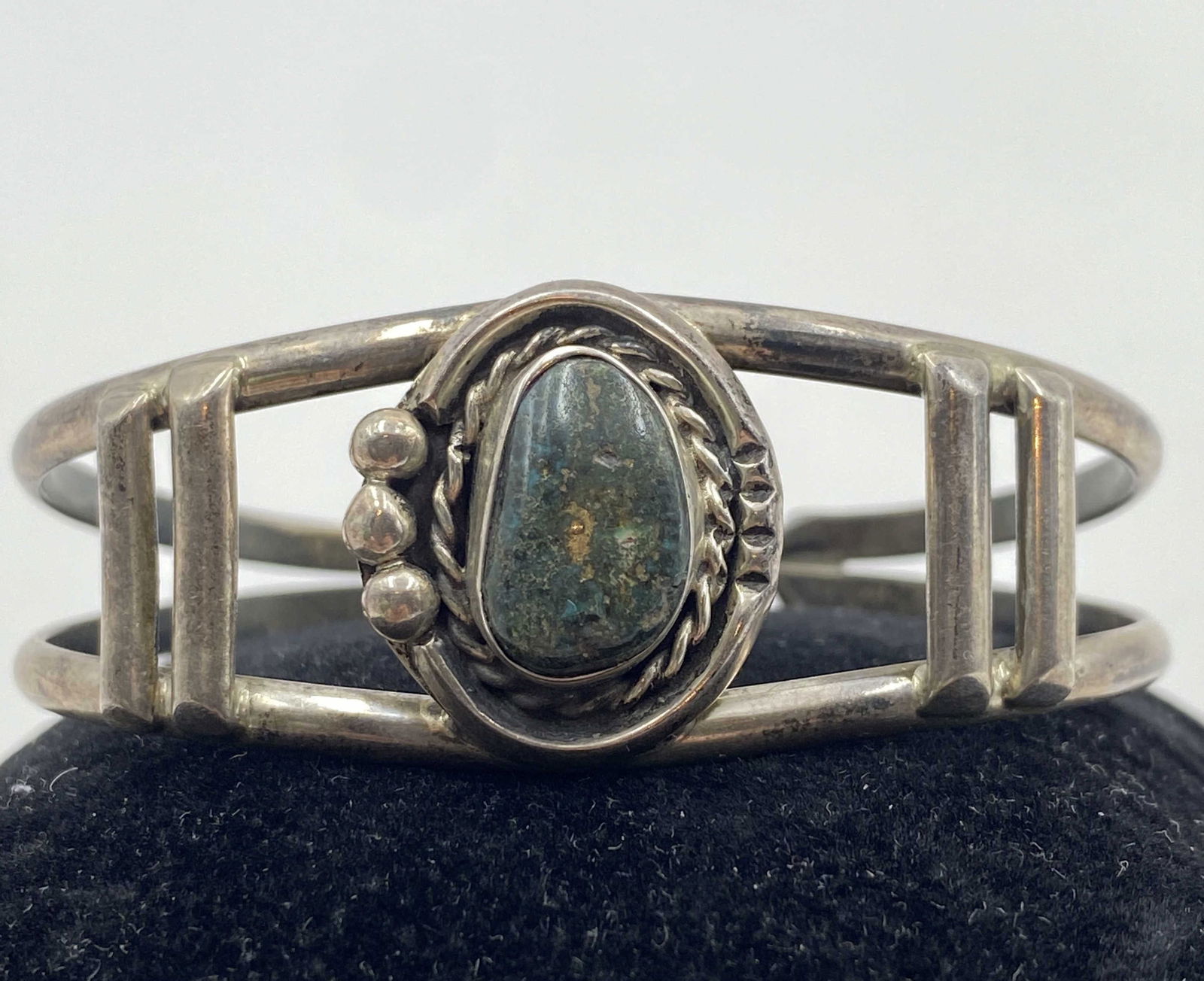 BLACK AND GREEN TURQUOISE STERLING BRACELET: NATIVE AMERICAN HANDMADE CUFF BRACELET. HAS ILLEGIBLE MARKS. TESTED STERLING SILVER. HEIGHT IS 7/8". GAP IS 1-1/2" FLEXIBLE AND FITS 6-3/4" WRIST TOTAL. WEIGHS 19 GRAMS. USA SHIPPING $5.