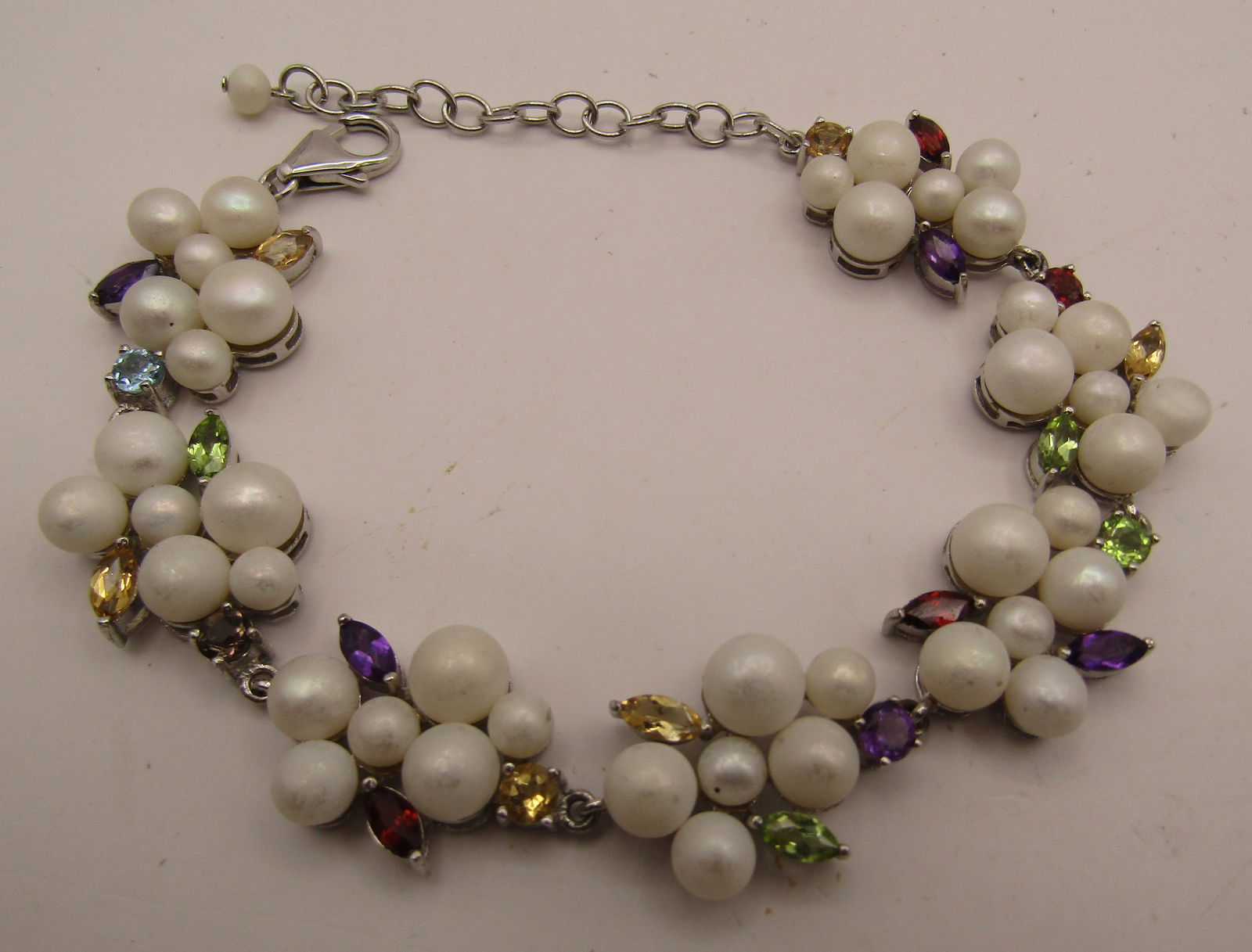 9.5" BRACELET STERLING SILVER PEARL MULTI GEMSTONE: GENUINE STERLING SILVER BRACELET WITH PEARL, AMETHYST, PERIDOT, GARNET, BLUE TOPAZ, CITRINE. MEASURES 9.5 INCHES LONG. WEIGHS 27.4 GRAMS. EXCELLENT USED CONDITION. USA SHIPPING $5.