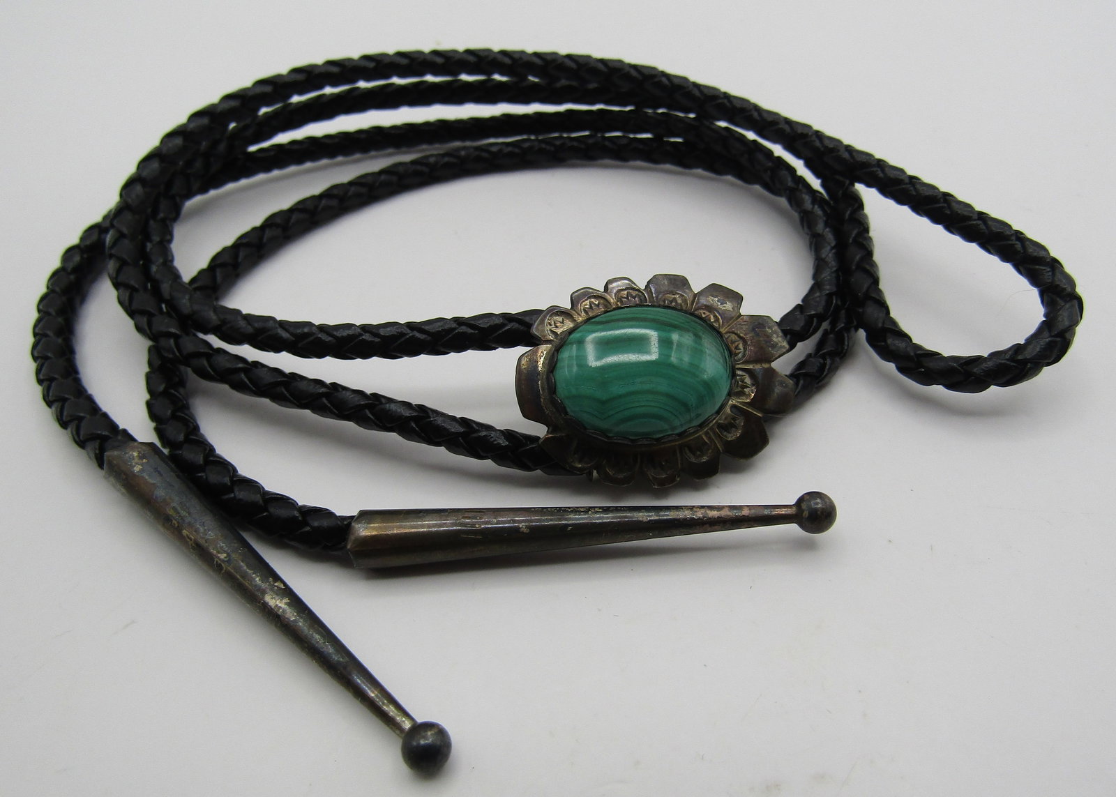 "?S?" MALACHITE BOLO TIE NECKLACE STERLING SILVER: VINTAGE ESTATE ARTIST HALLMARKED "?S? STERLING" BOLO. NATIVE AMERICAN SOUTHWEST NAVAJO INDIAN JEWELRY. BRAIDED LEATHER MEASURES 38 INCHES LONG INCLUDING TIPS AND 1 INCH LONG BOLO PENDANT. WEIGHS 18.7