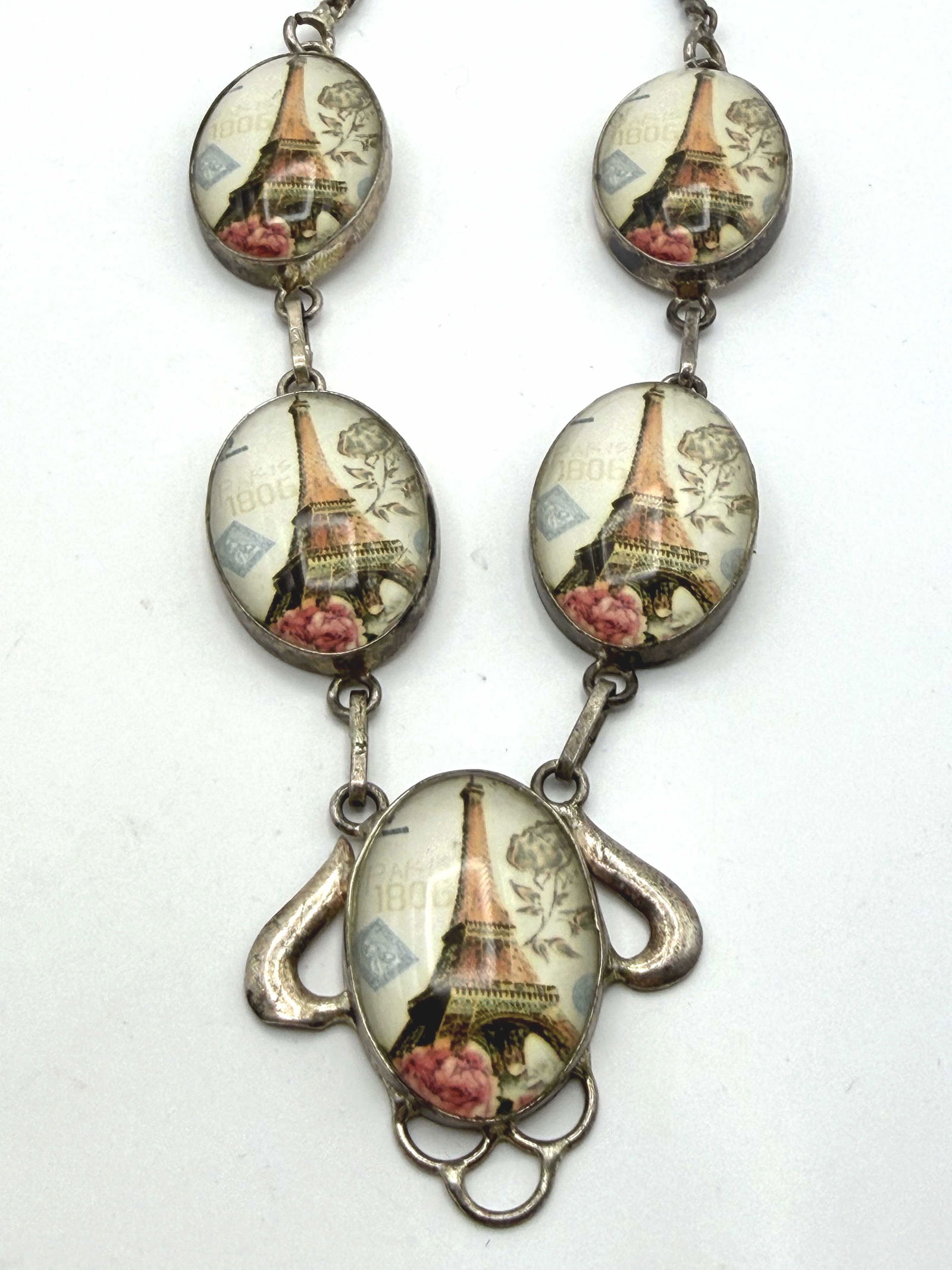 STERLING EIFFEL TOWER PARIS FRANCE CAMEO NECKLACE: EACH PART HAS PARIS 1806 COLORED PRINT UNDER GLASS IN A CAMEO STYLE. WEIGHS 29.8 GRAMS. MEASURES 20.5". CENTER PENDANT IS 1.25" X 1.25". WITH IMPERIAL AUCTION THE COST FOR PACKING AND SHIPPING VIA USP