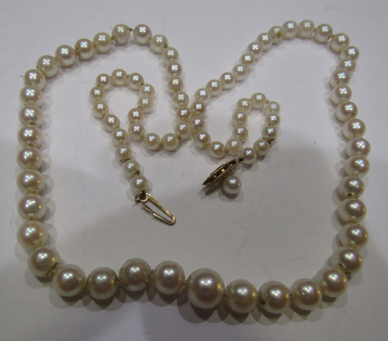 14K GOLD 19" GRADUATED 8MM PEARL NECKLACE: VINTAGE ESTATE GRADUATED 4MM TO 8MM CULTURED PEARL NECKLACE. MARKED "14KT" YELLOW GOLD FILIGREE CATCH. WEIGHS 17.5 GRAMS. EXCELLENT USED CONDITION. WITH IMPERIAL AUCTION THE COST FOR PACKING