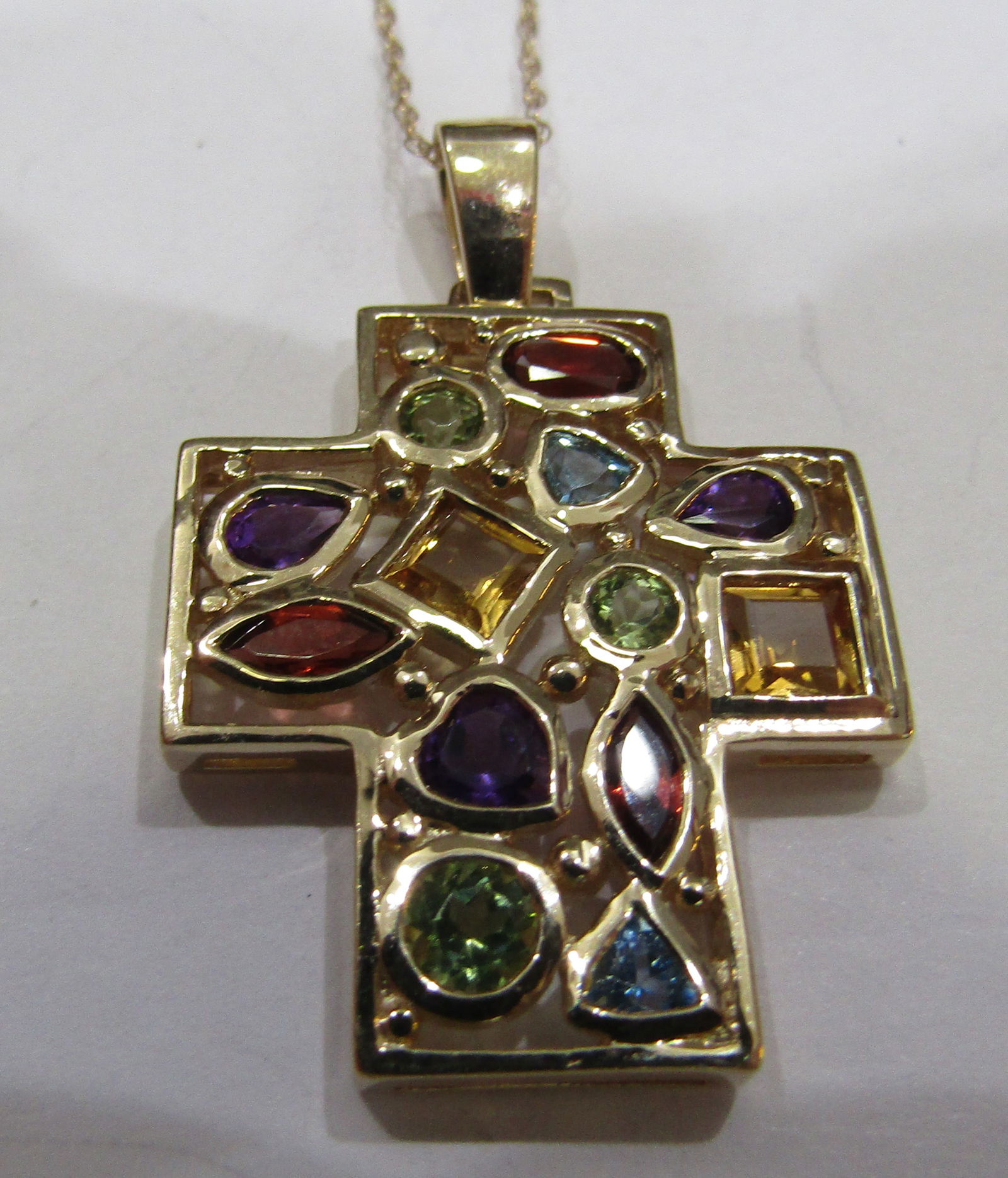 2.5CT GEMSTONE ENCRUSTED CROSS 14K GOLD NECKLACE: 18 INCH LONG 14K GOLD CHAIN AND GENUINE 2.5 CARAT CROSS WITH 13 GEMSTONES; GARNET, AMETHYST, PERIDOT, CITRINE AND BLUE TOPAZ. VINTAGE ESTATE MOUNTED IN 14K YELLOW GOLD. WEIGHS 5.8 GRAMS. 