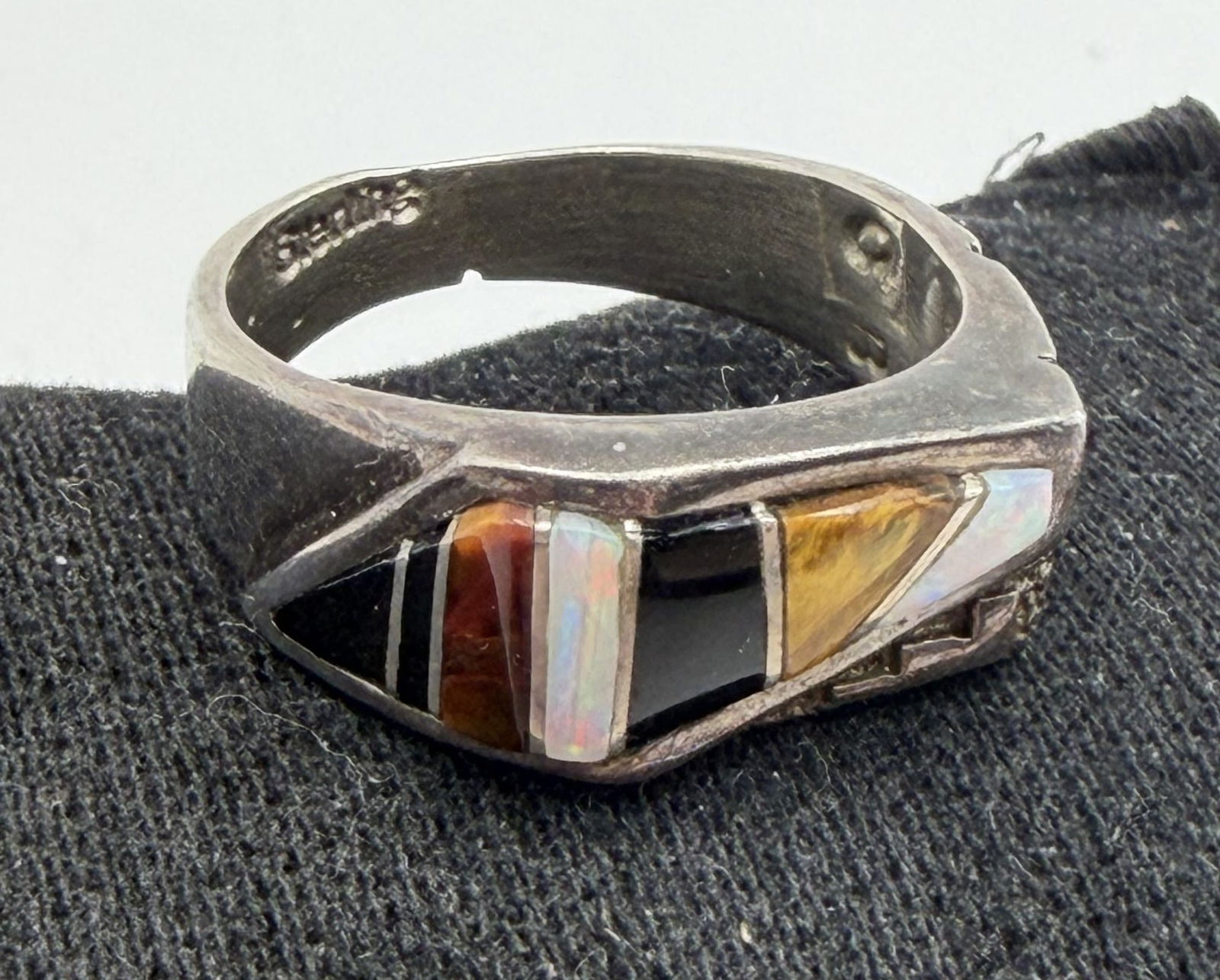 CALVIN BEGAY STERLING OPAL ONYX TIGEREYE RING: NATIVE AMERICAN HANDMADE RING WITH TIGERSEYE. SIGNED "CB" FOR CALVIN BEGAY TESTED STERLING SILVER. FACE MEASURES 1/4". RING SIZE 7.5. WEIGHS 5.7 GRAMS. WITH IMPERIAL AUCTION THE COST FOR PACKING AND S