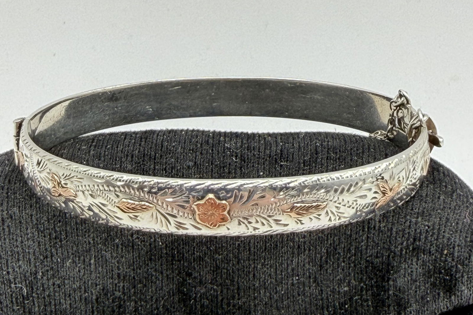 MARGARET LEE NAVAJO STERLING GOLD BRACELET: NATIVE AMERICAN HANDMADE HINGED BANGLE BRACELET WITH GOLD LEAVES. SIGNED "M.L." MARKED TESTED STERLING SILVER. FITS 7" WRIST. WEIGHS 19 GRAMS. WITH IMPERIAL AUCTION THE COST FOR PACKING AND SHIPPING V