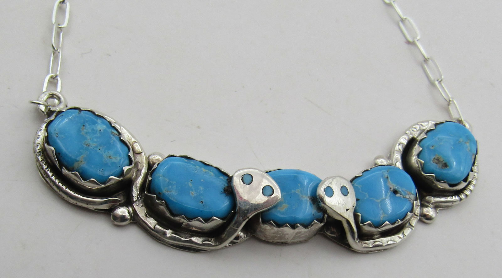 EFFIE CALAVAZA TURQUOISE NECKLACE STERLING SILVER: INLAY TURQUOISE EYE SNAKE DESIGN NECKLACE SIGNED "EFFIE C ZUNI" CALAVAZA TESTED STERLING SILVER. NATIVE AMERICAN SOUTHWEST ZUNI INDIAN JEWELRY. MEASURES 20 INCHES LONG. WEIGHS 17.1 GRAMS. EXCELLENT CO