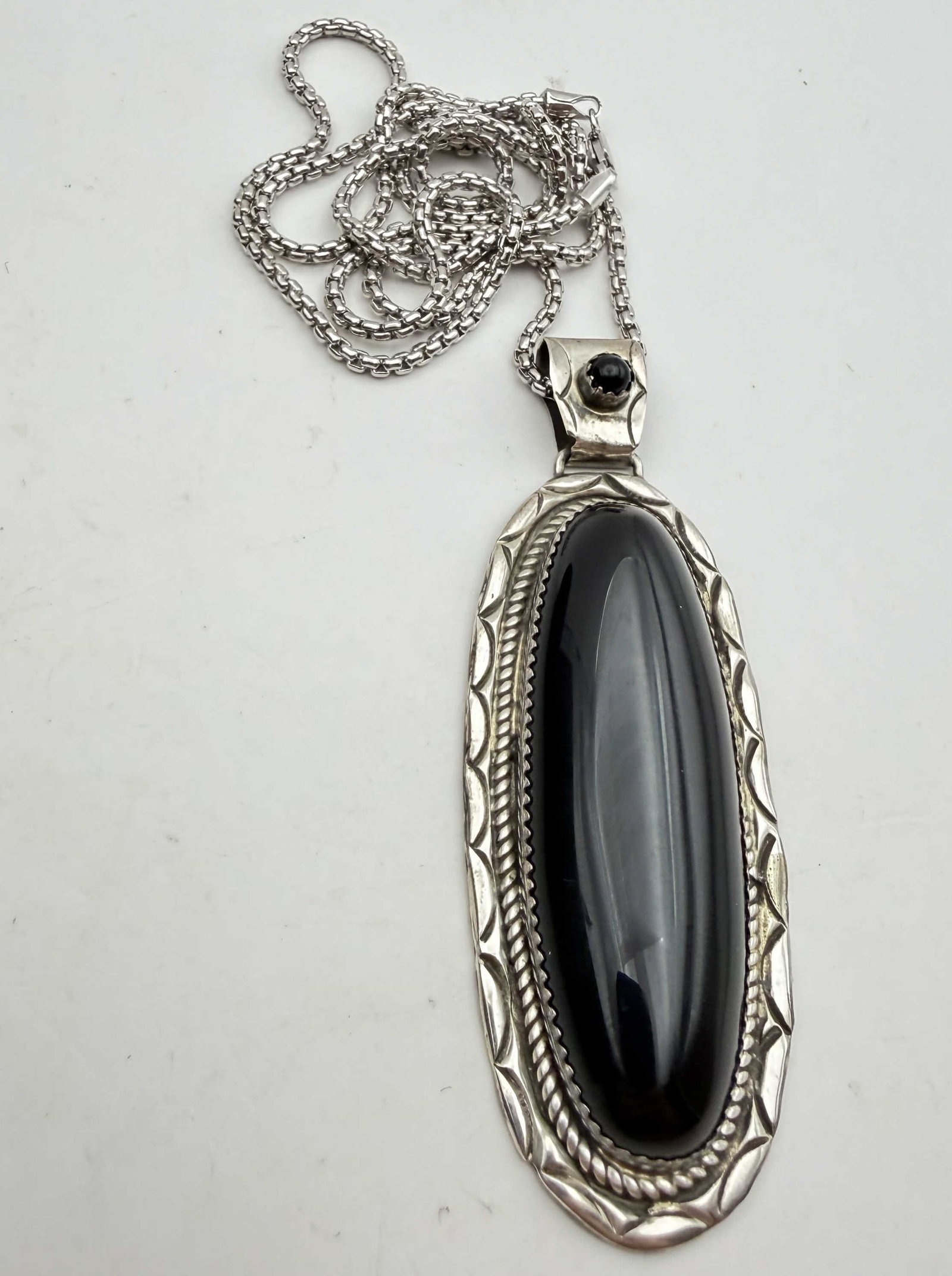 3" STERLING 33 GRAM ONYX NATIVE AMERICAN NECKLACE: NATIVE AMERICAN HANDMADE ELONGATED ONYX PENDANT. UNSIGNED UNMARKED TESTED STERLING SILVER. MEASURES 3" TALL WITH BAIL AND 1" WIDE. STERLING BOX CHAIN IS 24" LONG. WEIGHS 33 GRAMS TOTAL. WITH IMPERIAL 