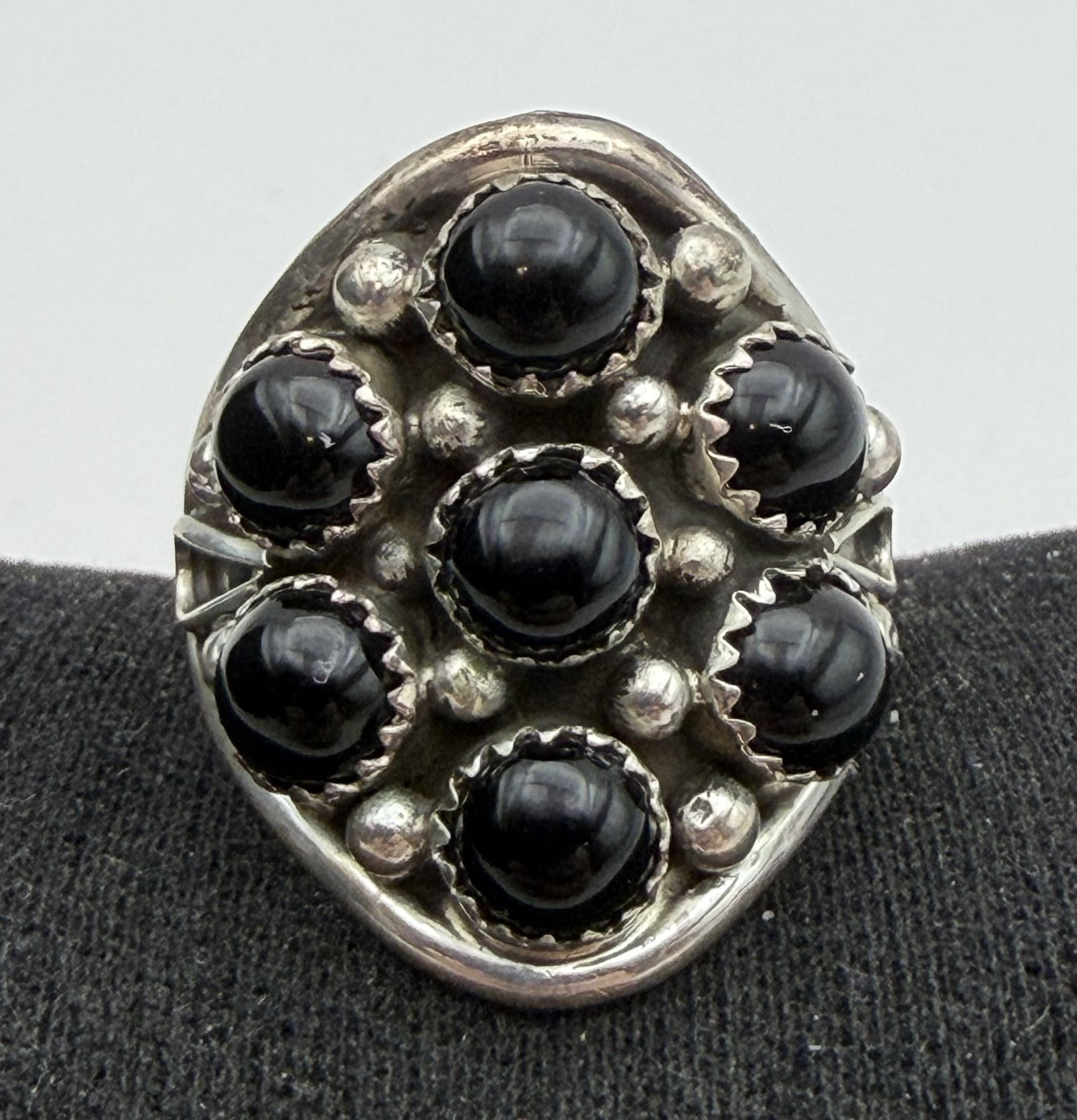 SIZE 11 STERLING ONYX CLUSTER RING NATIVE AMERICAN: NATIVE AMERICAN HANDMADE ONYX CLUSTER RING. UNSIGNED MARKED TESTED STERLING SILVER. FACE OF RING IS 1" NORTH SOUTH. WEIGHS 8.5 GRAMS. RING SIZE 11. WITH IMPERIAL AUCTION THE COST FOR PACKING AND SHIPP
