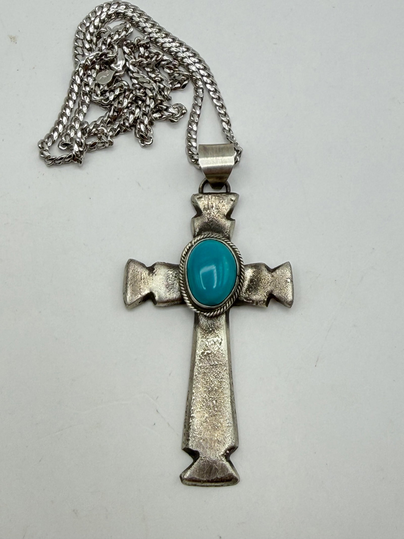 TOLINO NAVAJO STERLING TURQUOISE CROSS NECKLACE: NEW OLD STOCK NATIVE AMERICAN HANDMADE SAND CAST TURQUOISE CROSS PENDANT. SIGNED "RT" FOR RICK TOLINO MARKED TESTED STERLING SILVER. PENDANT IS 2-3/4" WITH BAIL X 1-3/8". CHAIN IS 20". WEIGHS 28