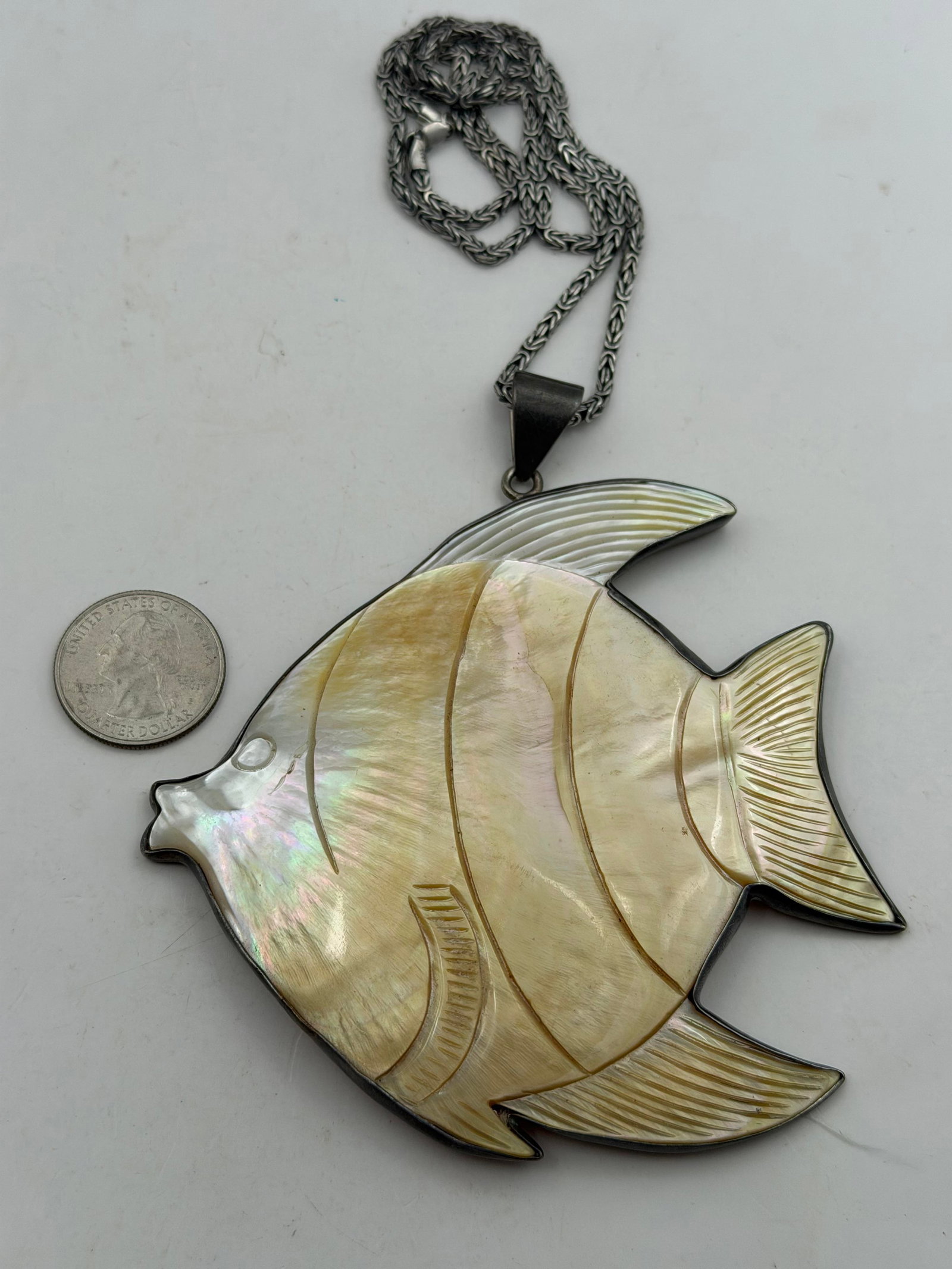 LARGE 4" CHARLES ALBERT STERLING SHELL ANGEL FISH: GORGEOUS CARVED MOTHER OF PEARL SHELL IN THE SHAPE OF A YELLOW AND WHITE ANGEL FISH. HAS SOME NATURAL IMPERFECTIONS NO REAL CRACKS. SIGNED CHARLES ALBERT TESTED STERLING SILVER. MEASURES 4.5" WITH