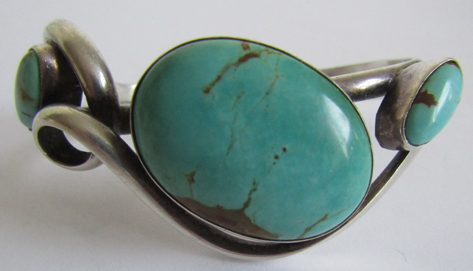 "G" TURQUOISE CUFF BRACELET STERLING SILVER 34GR: ARTIST HALLMARKED "G STERLING" VINTAGE ESTATE GENUINE GEM TURQUOISE BRACELET. NATIVE AMERICAN SOUTHWEST NAVAJO INDIAN JEWELRY. FITS A 7 1/2" WRIST WITH A 1.25" GAP. CENTER TURQUOISE MEASURES 1.25 INCH