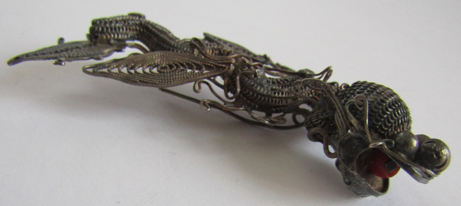 2 3/4" STERLING SILVER FILIGREE DRAGON PIN BROOCH: ANTIQUE HANDCRAFTED FILIGREE WORK DRAGON PIN. MEASURES 2 3/4 INCHES WIDE. WEIGHS 12.3 GRAMS. EXCELLENT ANTIQUE CONDITION. WITH IMPERIAL AUCTION THE COST FOR PACKING AND SHIPPING VIA USPS IN THE USA IS