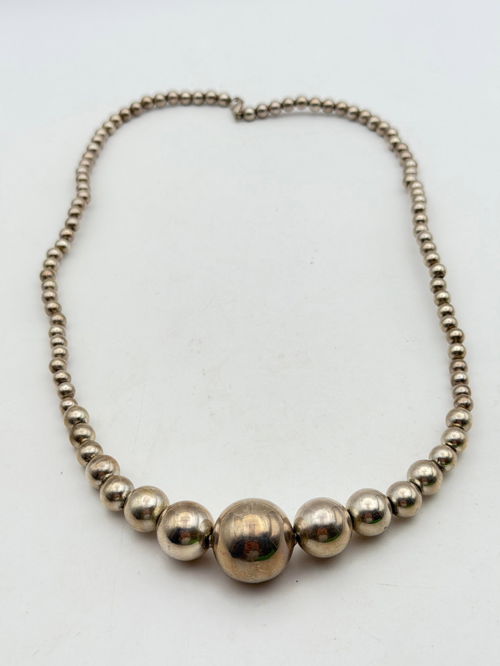 40g STERLING SILVER GRADUATED BALL BEADED NECKLACE: MARKED UNSIGNED TESTED STERLING SILVER. MEASURES 24". CENTER PEARL IS 23MM. WEIGHS 40.5 GRAMS TOTAL. WITH IMPERIAL AUCTION THE COST FOR PACKING AND SHIPPING VIA USPS IN THE USA IS $5.