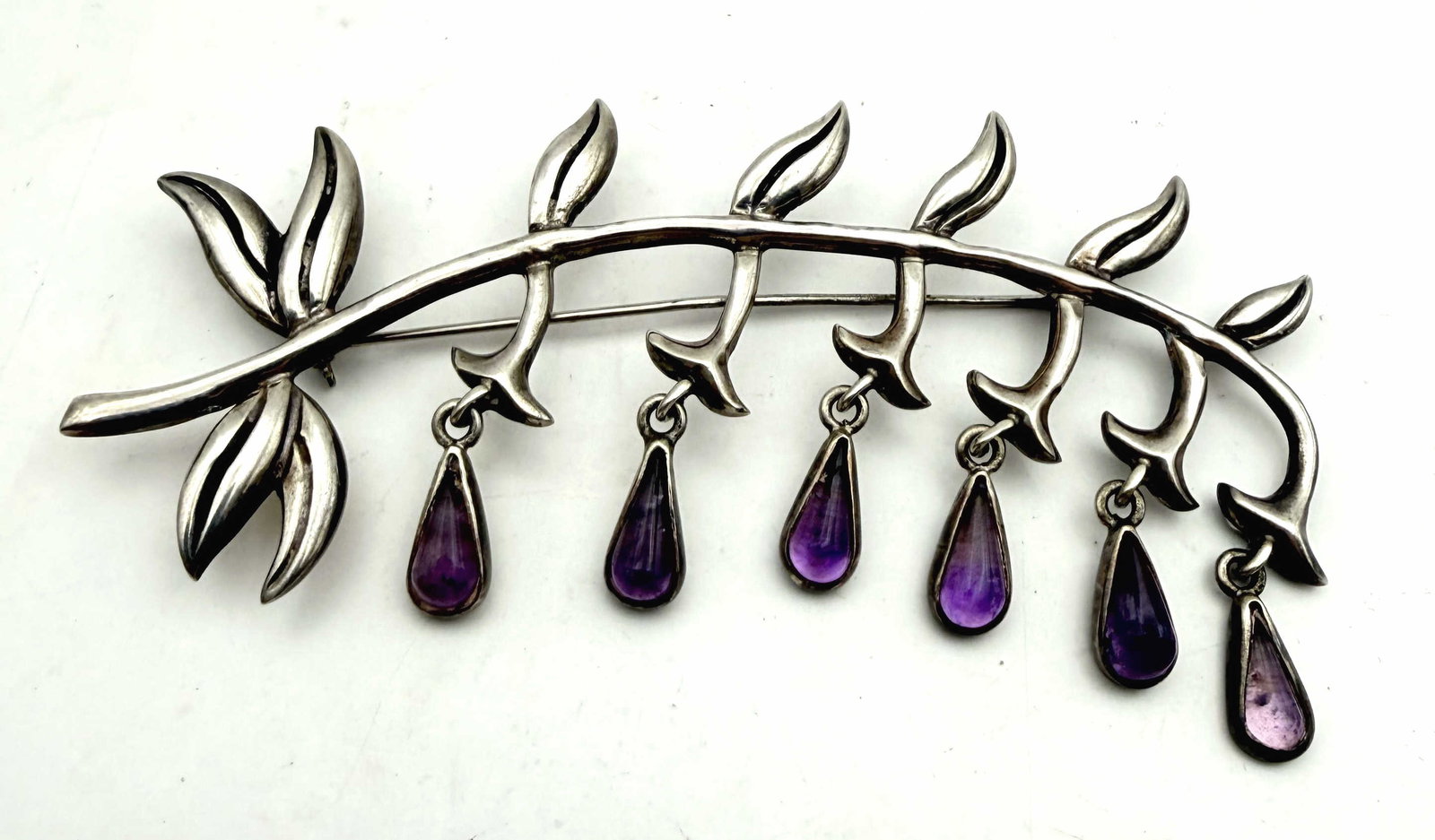 3.75" TAXCO AMETHYST VINTAGE STERLING PIN BROOCH: IN THE STYLE OF ANTONIA PINEDA, THIS PIN REPRESENTS A PURPLE LILY OF THE VALLEY FLOWERING BRANCH. SIGNED "DORIS MEXICO" FOR DORIS CORPUS ARTISANS. MARKED TESTED STERLING SILVER. MEASURES 3.75" X 1.75"