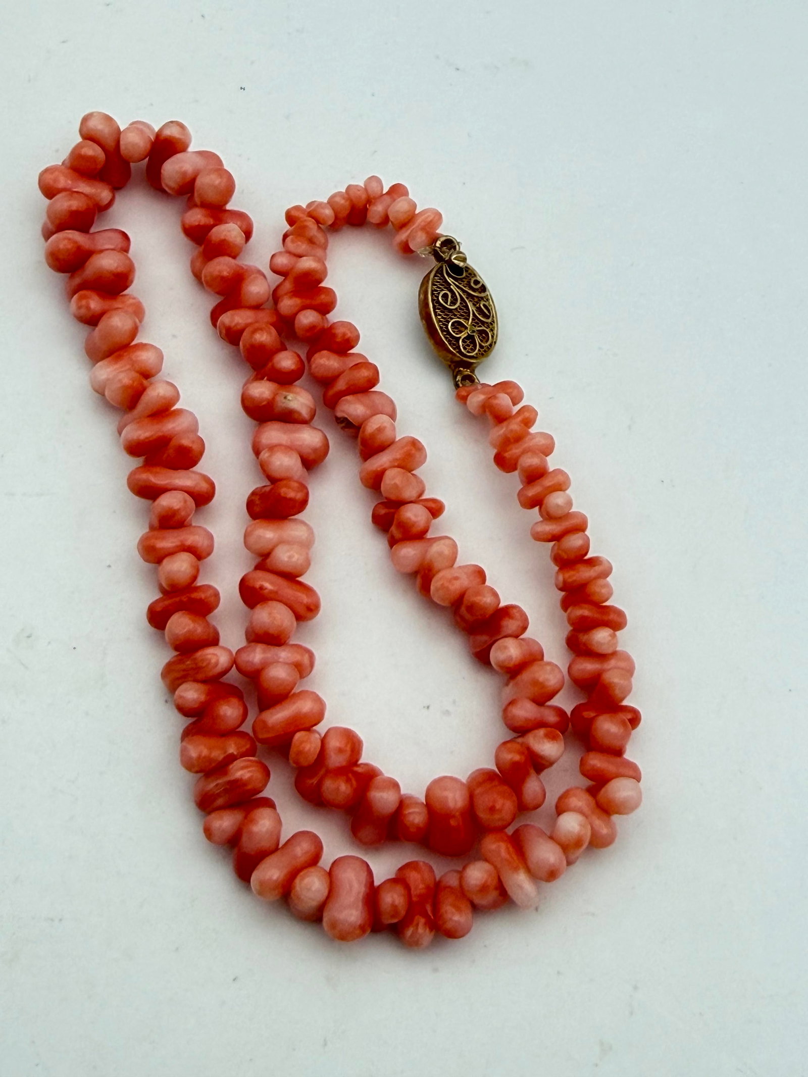 VINTAGE CORAL NECKLACE CHINESE EXPORT GOLD SILVER: ANGEL SKIN CORAL GREAT PINK TONES. GOLD VERMEIL CLASP. MARKED "SILVER" TESTED STERLING SILVER. MEASURES 15.5" LONG AND 3/8" WIDE BEADS ON AVERAGE. WEIGHS 24.2 GRAMS TOTAL. WITH IMPERIAL AUCTION THE CO