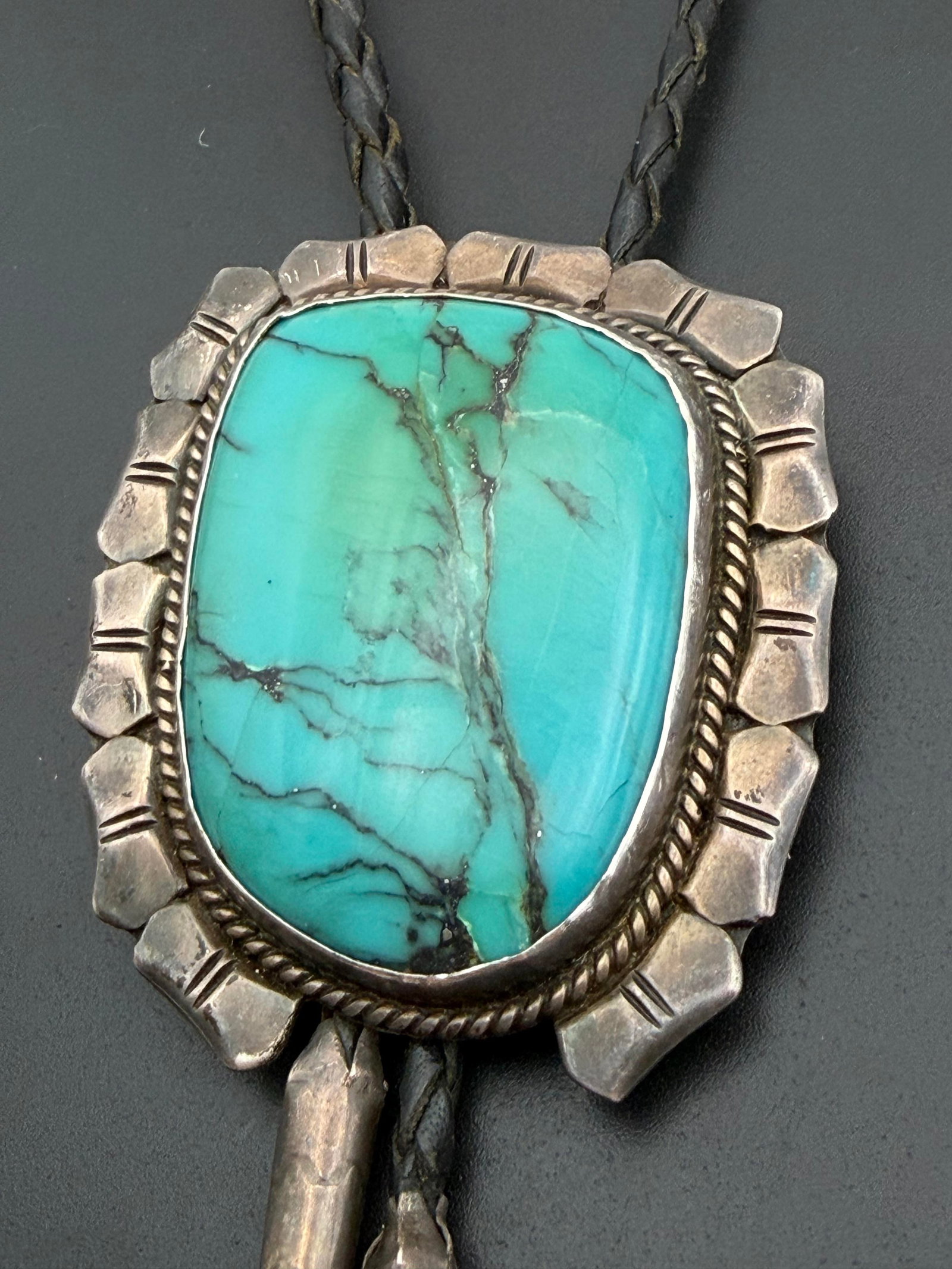 OLD PAWN LARGE STERLING NAVAJO BOLO TIE: VINTAGE 1960'S-1970'S NATIVE AMERICAN HANDMADE BOLO TIE NECKLACE. STONE HAS SOME HARD TO SEE CRACKS. UNSIGNED MARKED TESTED STERLING SILVER. PENDANT MEASURES 2.75" X 2.25". LEATHER CORD IS 39" WITH ST