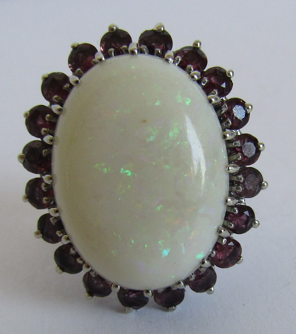 16CT NATURAL OPAL & 2CT RUBY RING 14K WHITE GOLD: LARGE OVAL AUSTRALIA OPAL 12MM BY 14MM 16 CARATS. SET WITH 20 ROUND NATURAL RED RUBIES 2 CARATS TOTAL. 14K WHITE GOLD RING SIZE 5 1/2 . WEIGHS 7.2 GRAMS. EXCELLENT USED CONDITION. USA SHIPPING USPS $5