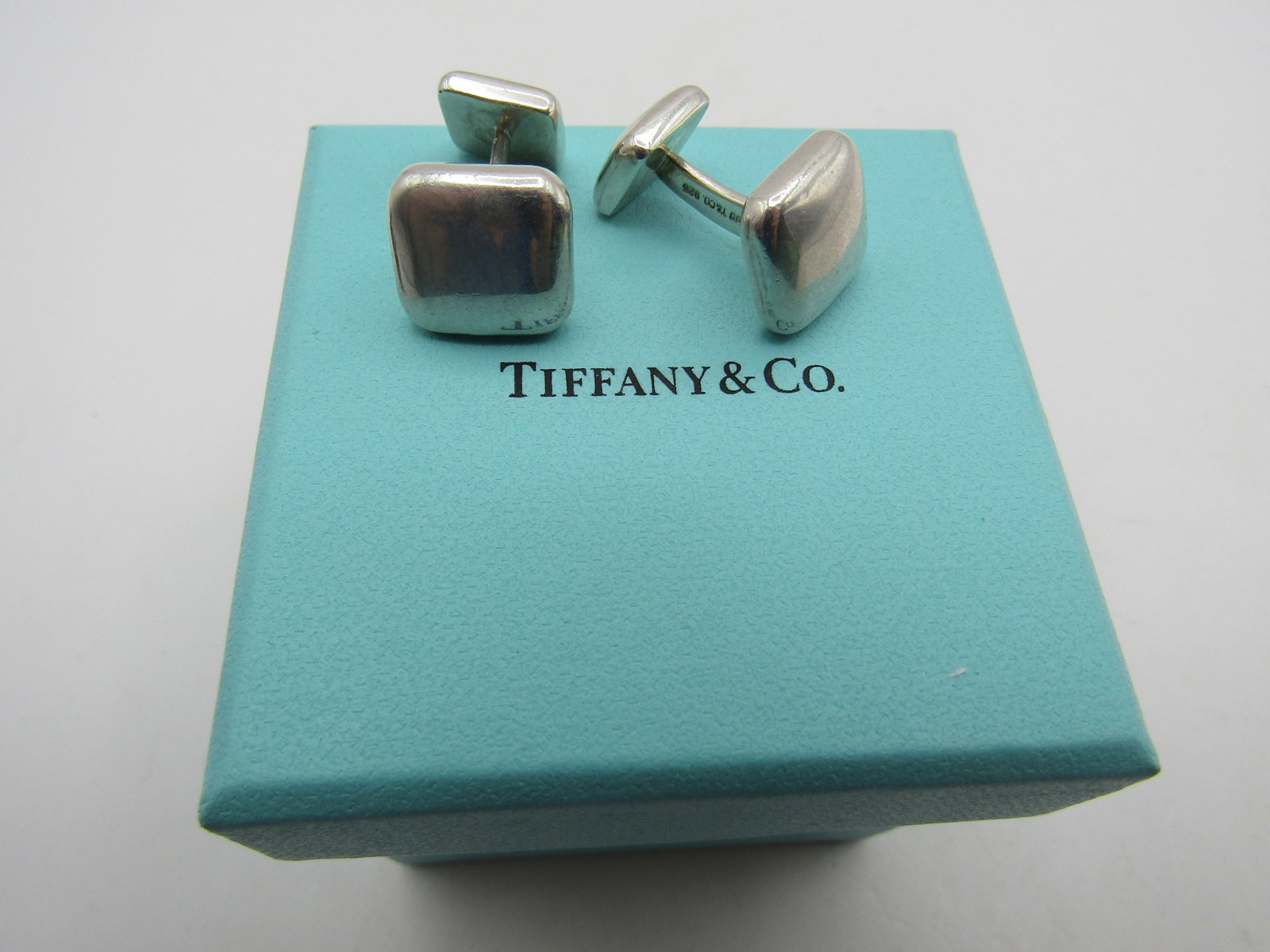 TIFFANY & CO CUFFLINKS STERLING SILVER 17.7GR 1999: GENUINE SIGNED "1999 T & CO. 925" WITH POUCH. MEASURES .5" BY .5". WEIGH 17.7 GRAMS STERLING SILVER. EXCELLENT USED CONDITION. WITH IMPERIAL AUCTION THE COST FOR PACKING AND SHIPPING VIA USPS IN THE U