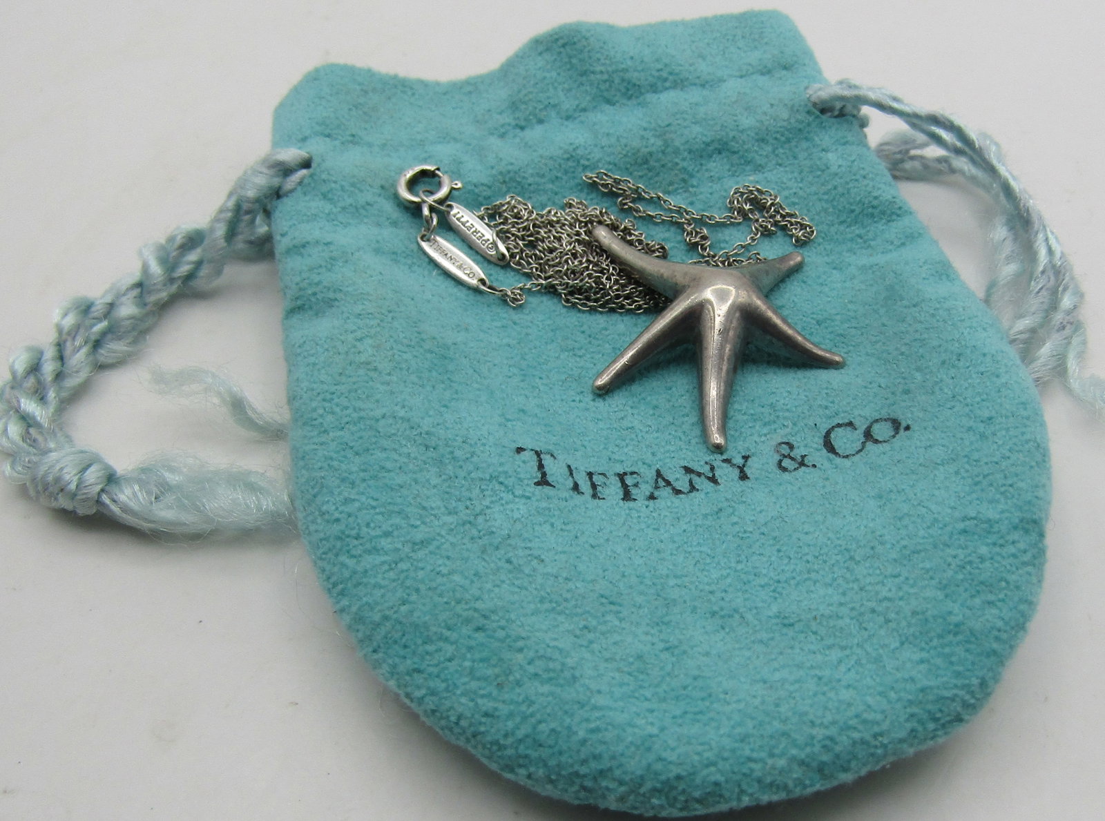 TIFFANY &CO 27" STAR FISH NECKLACE STERLING SILVER: GENUINE SIGNED "PERETTI, TIFFANY & CO. SPAIN, 925" WITH POUCH. LINK CHAIN MEASURES 27 INCHES LONG. WEIGHS 5.3 GRAMS STERLING SILVER. EXCELLENT USED CONDITION. WITH IMPERIAL AUCTION THE COST FOR PACKIN