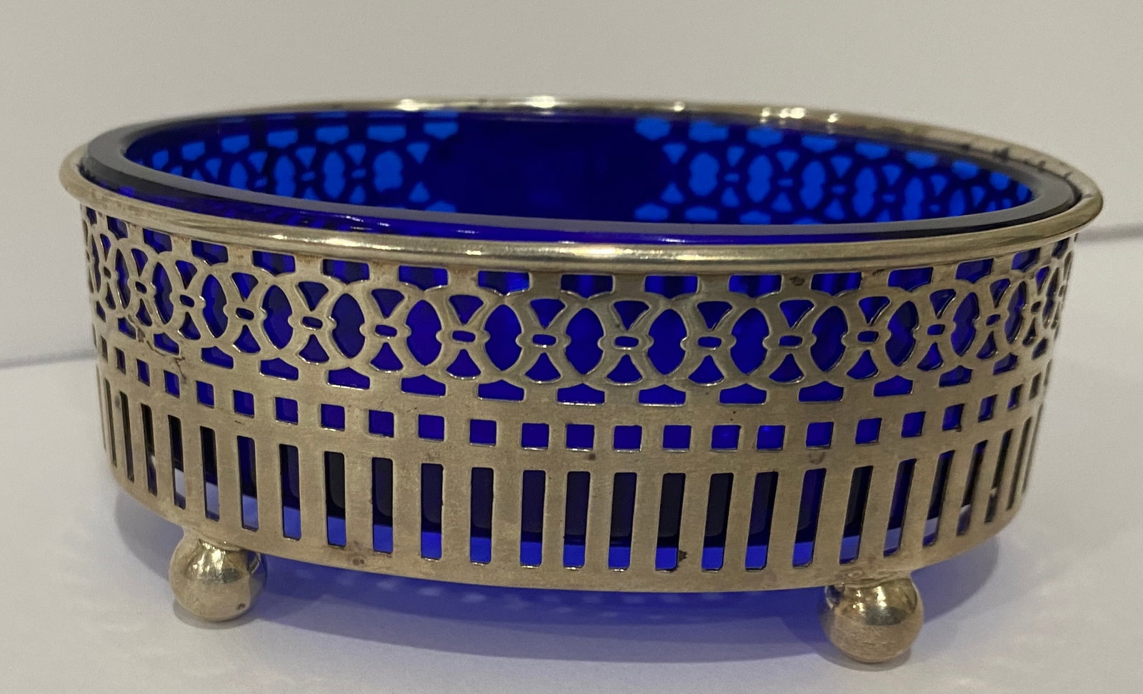 STERLING SILVER & COBALT SALT OR VANITY DISH: ANTIQUE BOWL HALLMARKED "CROWN, W, LION; STERLING 4705". MEASURES 3 3/8" BY 2 3/8" BY 1 3/8". STERLING SILVER WEIGHS 27.4 GRAMS; WITH COLBALT GLASS 135.5 GRAMS. EXCELLENT CONDITION, MONOGRAM "ABC". WI