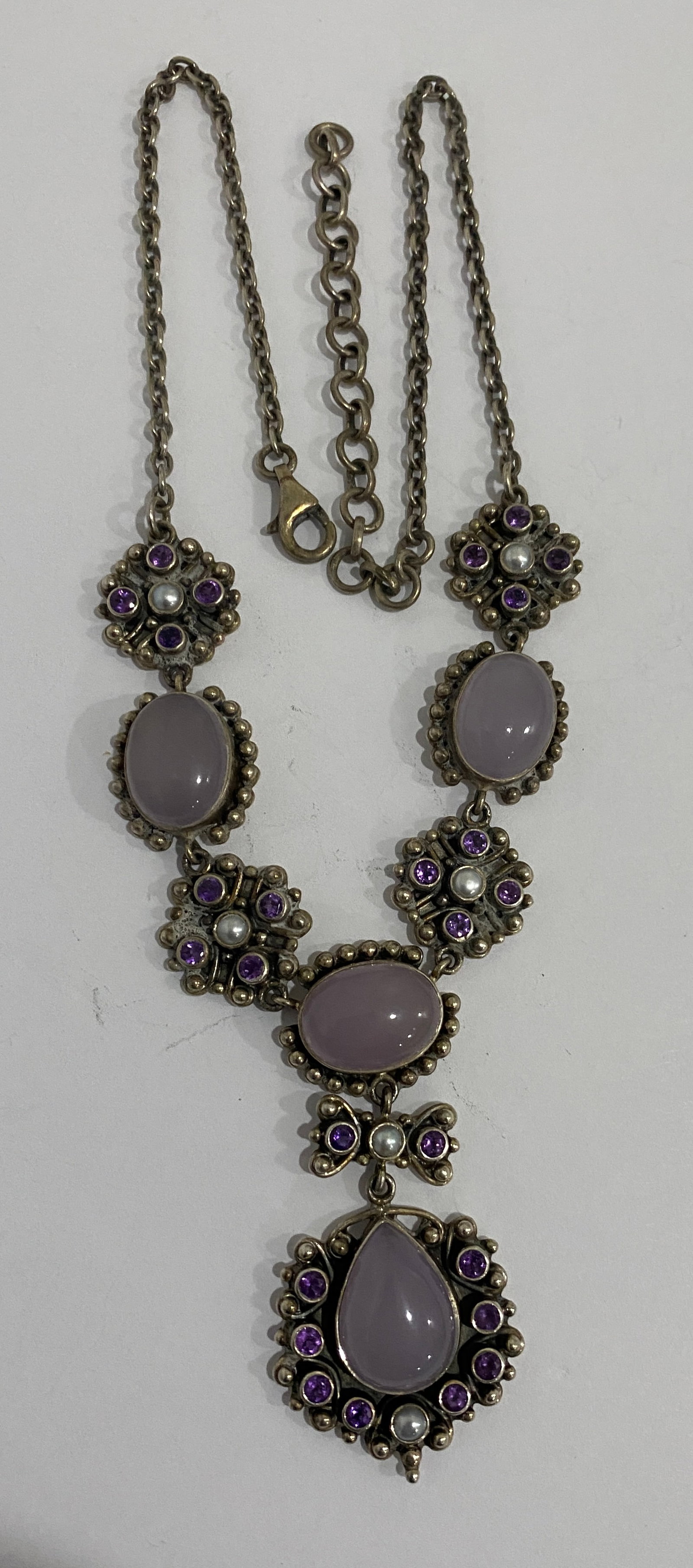 NICKY BUTLER GEMSTONE NECKLACE STERLING SILVER 46G: VINTAGE ESTATE HALLMARKED "NB INDIA 925". 20 INCH LONG STERLING SILVER NECKLACE WITH 4 ROSE QUARTZ STONES UP TO.75"; 26 AMETHYST STONES AND 5 PEARLS. WEIGHS 46.3 GRAMS. EXCELLENT CONDITION. WITH IMPER