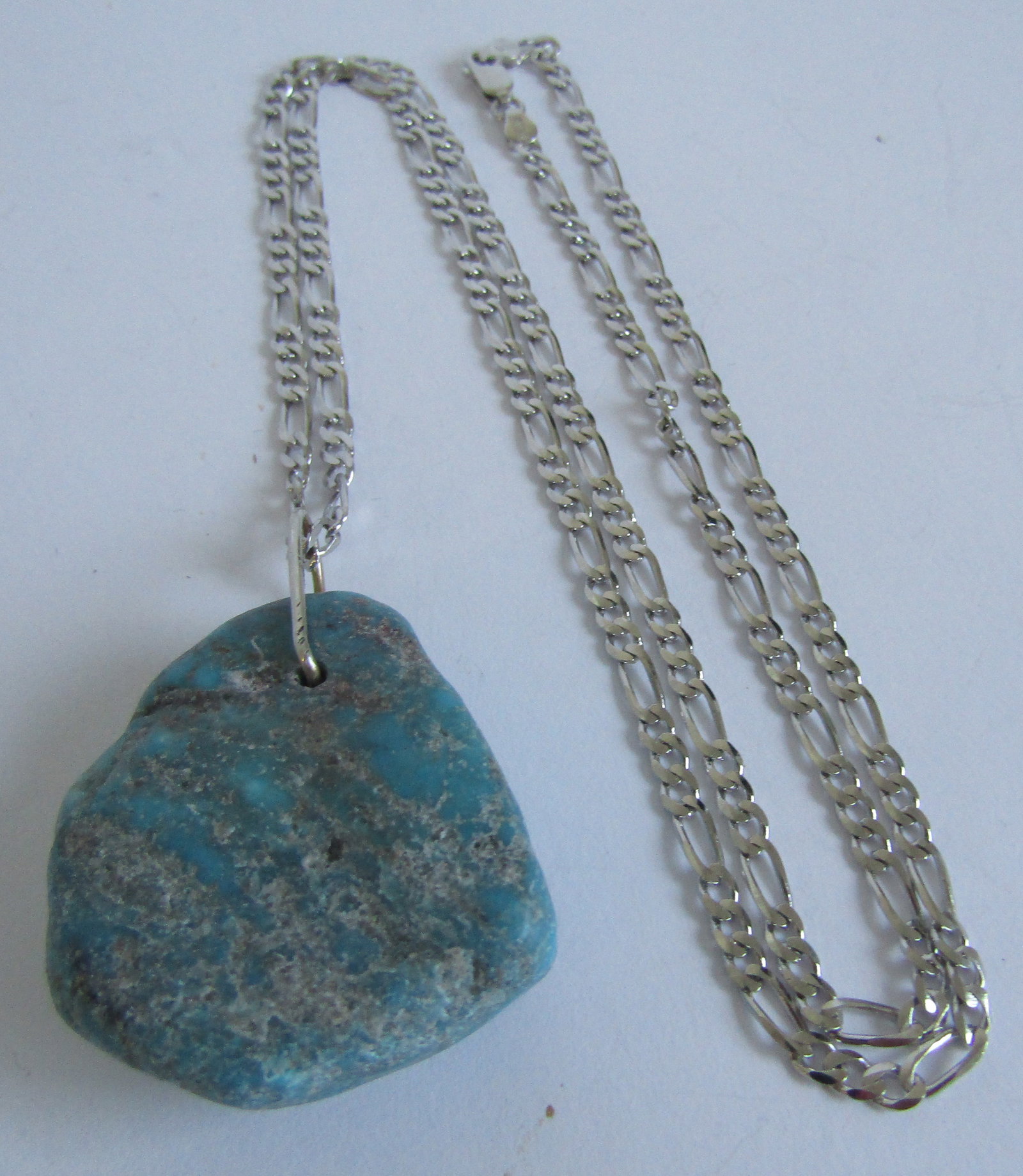 GENUINE TURQUOISE PENDANT STERLING SILVER NECKLACE: MEASURES 1.75 INCH LONG BY 1.25 INCH WIDE GENUINE SOLID TURQUOISE PENDANT. 25 INCH LONG FIGARO LINK CHAIN MARKED "ITALY 925", WEIGH 31.4 GRAMS. EXCELLENT CONDITION. WITH IMPERIAL AUCTION THE COST FOR 