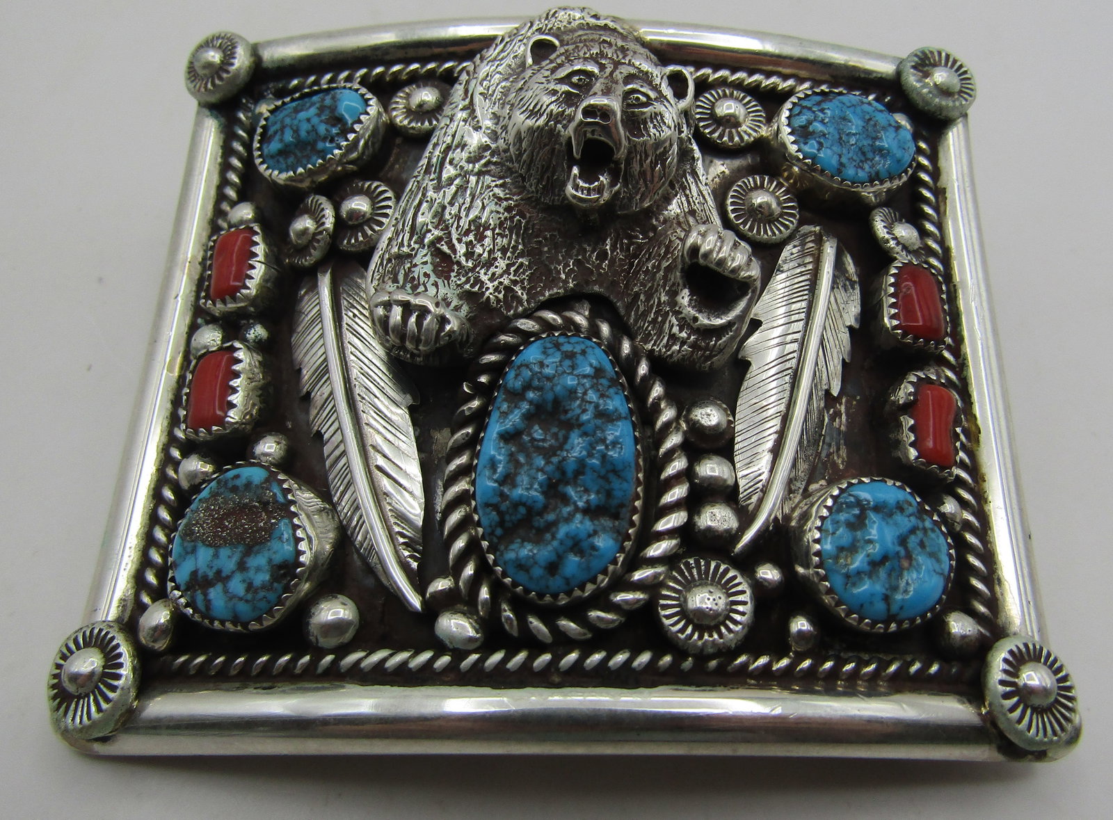 "HE" TURQUOISE CORAL BELT BUCKLE STERLING 93.7GRM: ARTIST HALLMARKED "HE STERLING" VINTAGE ESTATE GENUINE TURQUOISE AND RED CORAL BEAR BELT BUCKLE. NATIVE AMERICAN SOUTHWEST NAVAJO INDIAN JEWELRY. MEASURES 3 INCHES BY 2.5 INCHES. TESTED STERLING SILVE