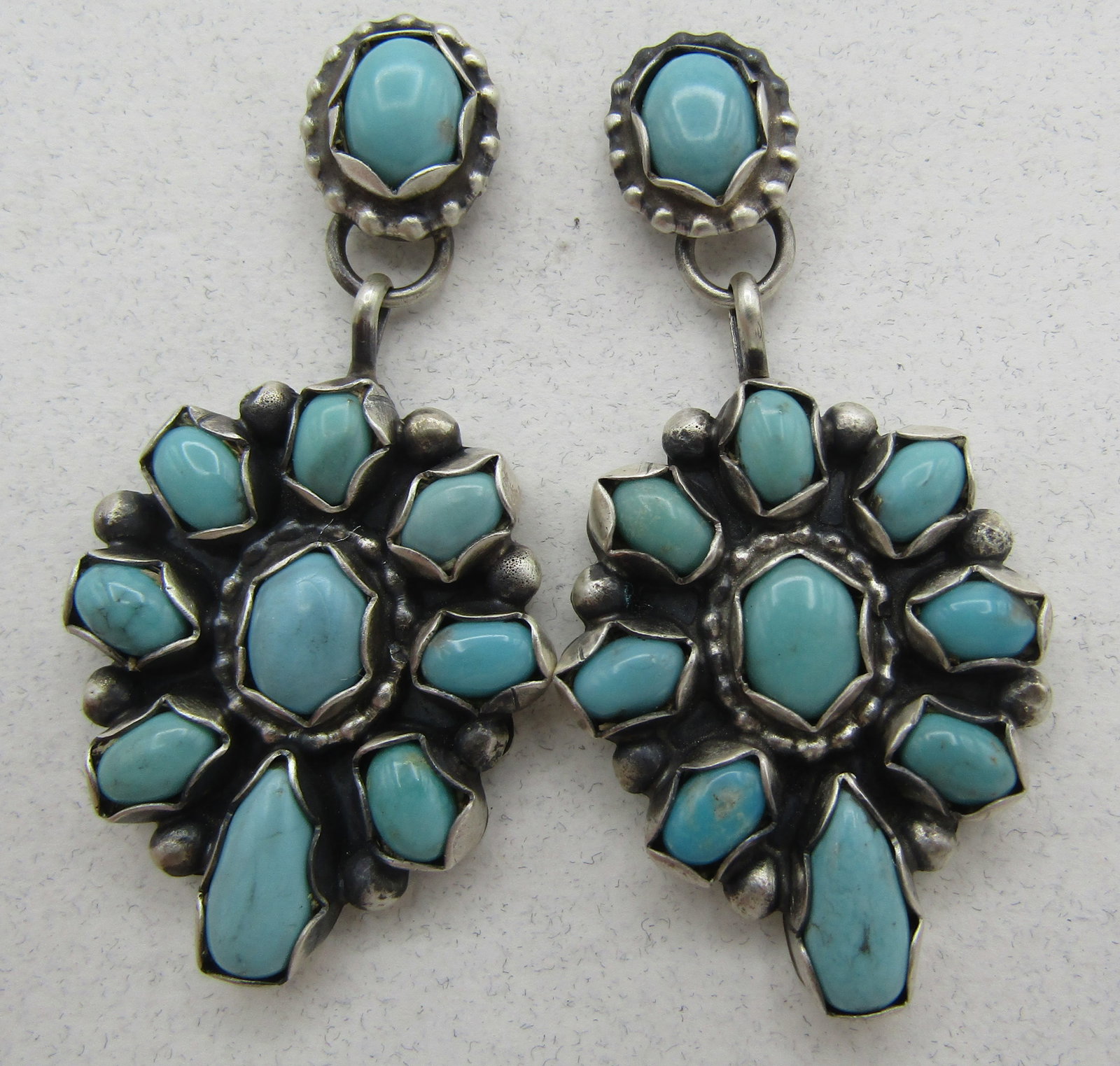 SHEILA TURQUOISE CLUSTER EARRINGS STERLING SILVER: ARTIST SIGNED "SHEILA STERLING"TURQUOISE CLUSTER EARRINGS. HANDMADE NATIVE AMERICAN SOUTHWEST NAVAJO INDIAN JEWELRY. MEASURE 2 INCHES LONG. WEIGH 16.5 GRAMS. EXCELLENT CONDITION. WITH IMPERIAL AUCTION