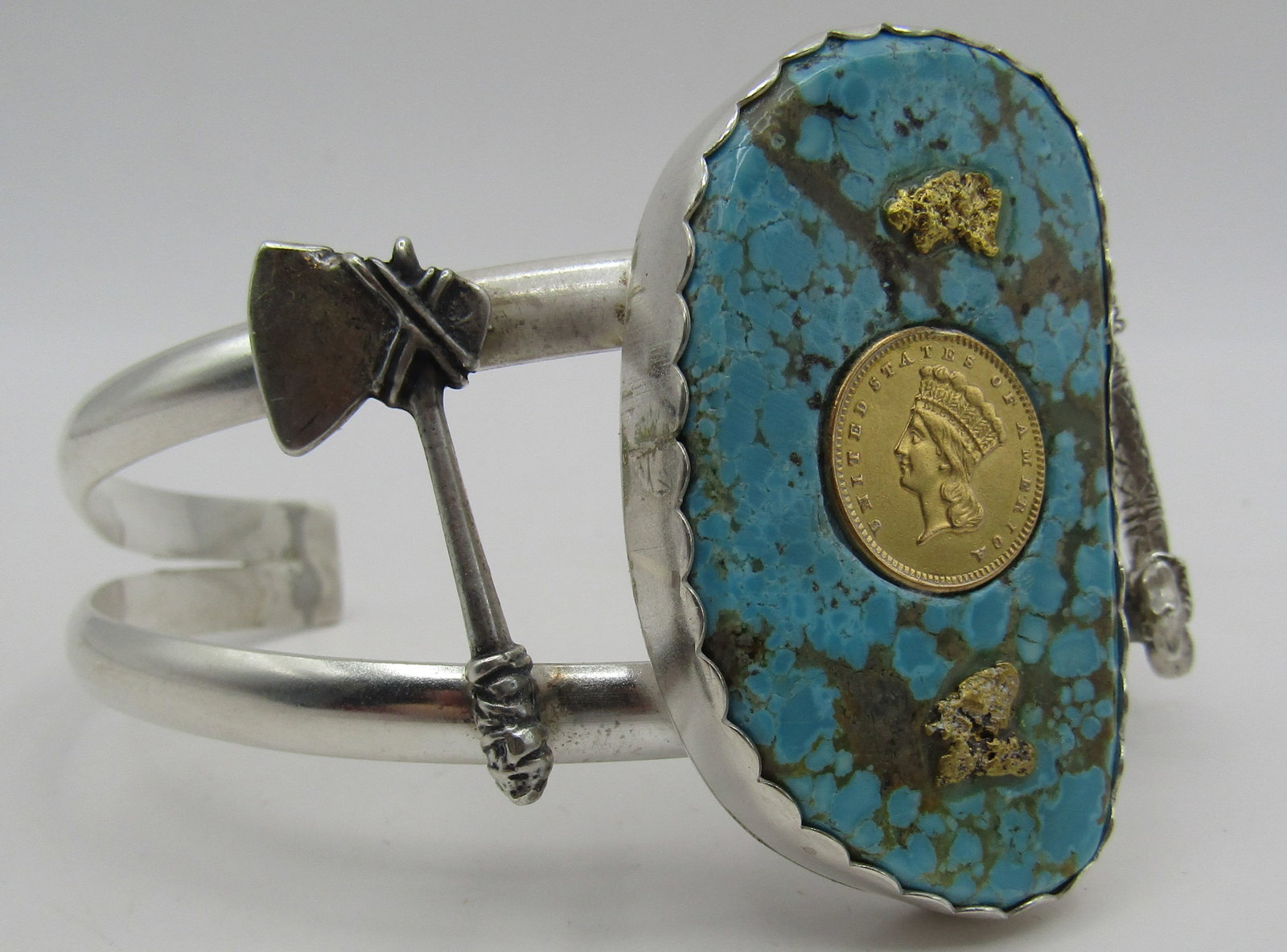 $1 GOLD COIN TURQUOISE 10" BRACELET STERLING SILVE: US 1 DOLLAR GOLD COIN, SOLID GOLD NUGGETS,GENUINE TURQUOISE; ALL MOUNTED IN STERLING SILVER. TOP MEASURES 2 INCHES WIDE. WEIGHS 73.1 GRAMS. FITS A 10 INCH WRIST WITH A 40MM GAP. EXCELLENT CONDITION. W