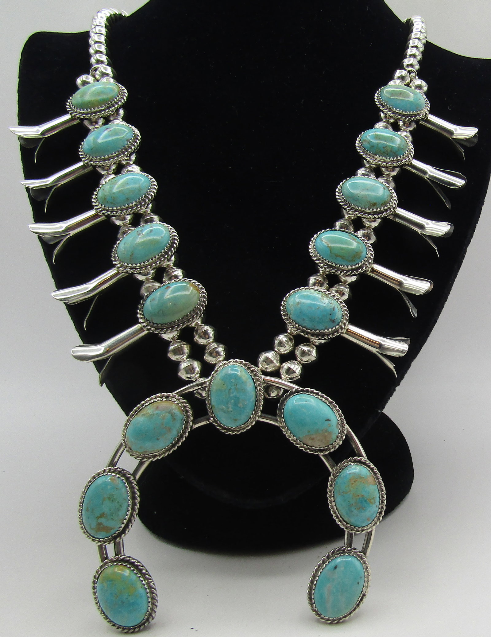 ROYSTON TURQUOISE SQUASH BLOSSOM NECKLACE STERLING: ROYSTON TURQUOISE STERLING SILVER SQUASH BLOSSOM NECKLACE BY GARRISON BOYD. HANDMADE NATIVE AMERICAN SOUTHWEST NAVAJO INDIAN JEWELRY. MEASURES 28" LONG PLUS 3" NAJA. WEIGHS 160.6 GRAMS. EXCELLENT COND