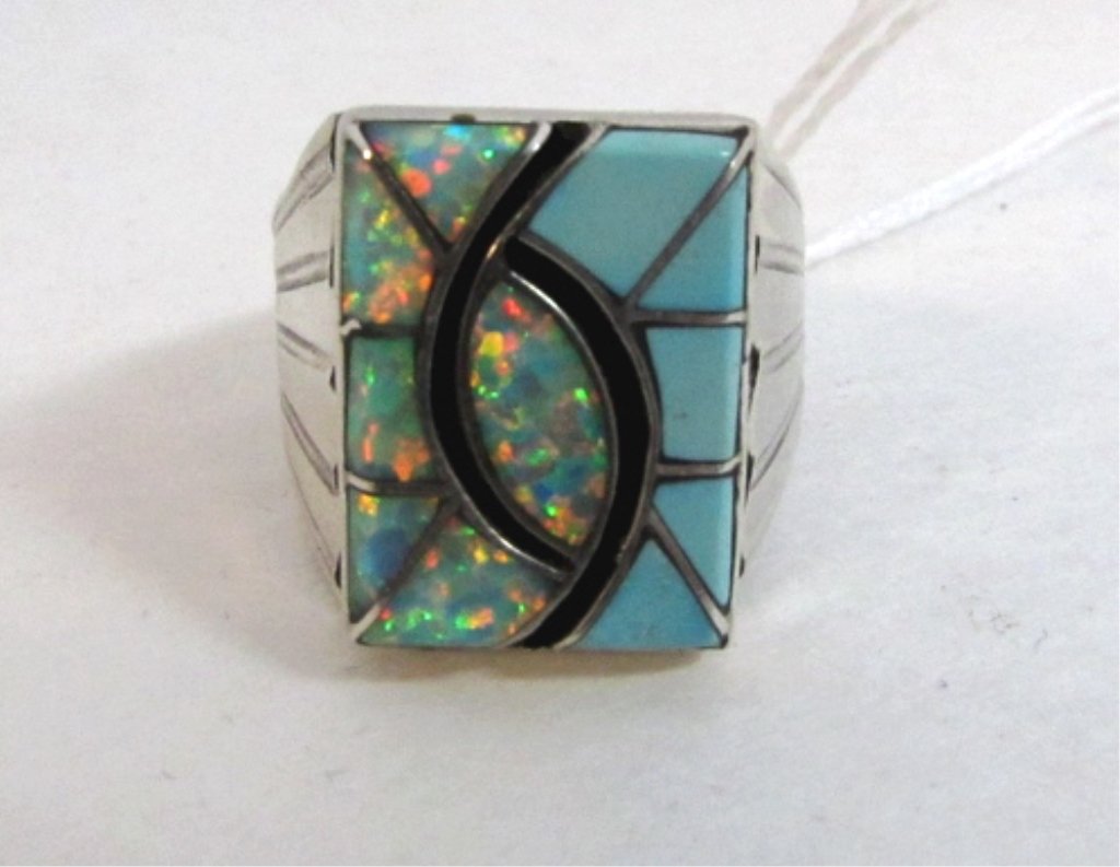 Norman Lee Opal & Turquoise Sterling Man's Ring: 128.2. Navajo artist Norman Lee. Inlaid turquoise and opal made into a high arm/friendship shake design. Stones silver channel raised inlay beveled cut edge. Size 10. Weighs 11.3 grams.