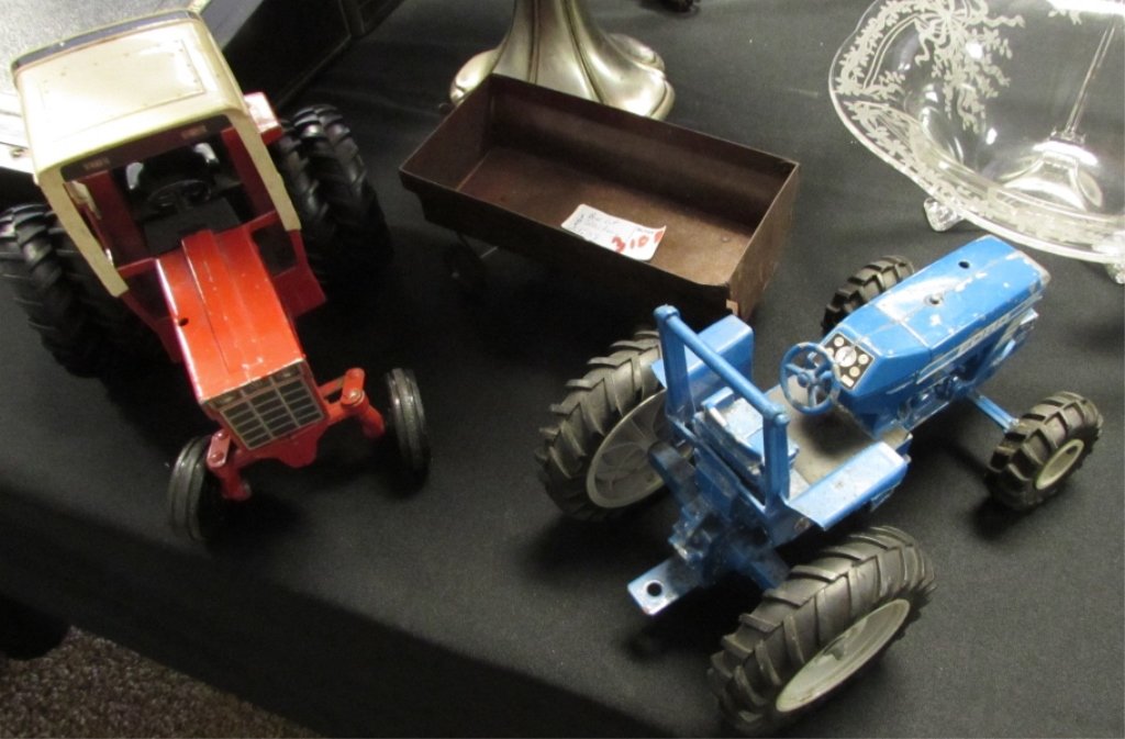BLUE FORD TRACTOR, RED INTERNATIONAL HARVESTER IH: 25.38. BLUE FORD TRACTOR MARKED "ERTL" MEASURES 10" BY 6". RED IH, INTERNATIONAL HARVESTER MEASURES 9" BY 7 1/4" . TRAILER MEASURES 10" BY 4".