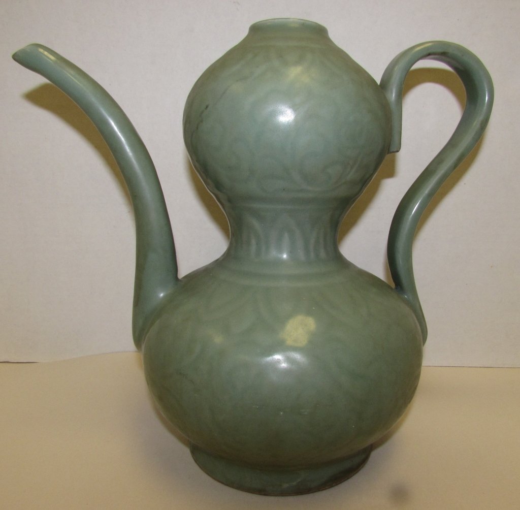 CELADON PITCHER JUG CHINA OR KOREA: 2.0 CELADON PITCHER. HANDLE & SPOUT. UNIQUE DESIGN. MEASURES 10" TALL x 11" AT WIDEST POINT. NO CHIPS, NO CRACKS.