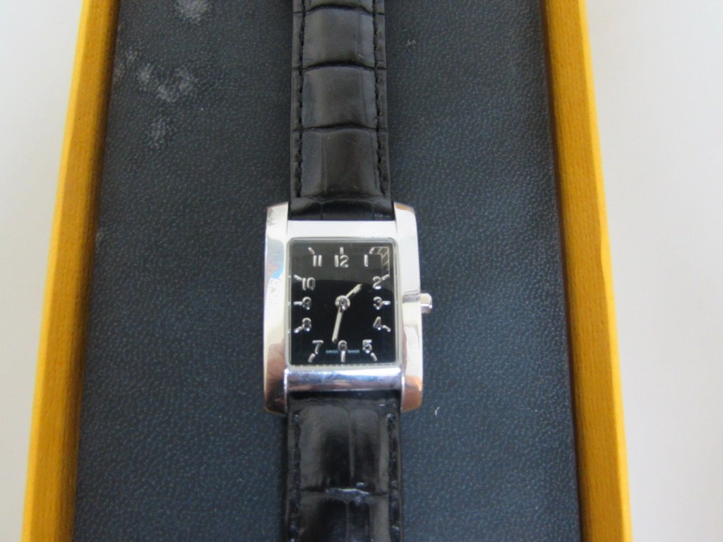 FENDI WATCH 7000L LADYS WATCH BOX & PAPERS: 52.16 STAINLESS STEEL WRISTWATCH WITH BLACK DIAL AND ORIGINAL LEATHER STRAP BAND WATCH MEASURES 8" LONG THE CASE MEASURES 30MM LUG TO LUG AND 21MM WITHOUT THE CROWN