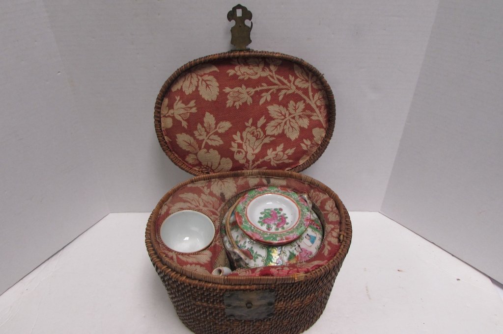 ROSE MEDALLION TEA SET IN WICKER CARRYING CASE: 159.65 ANTIQUE CHINESE ROSE MEDALLION TEAPOT w/ LID, MATCHING CUP IN FITTED WICKER BASKET. BASKET IS 7.5" TALL x 10" WIDE x 8" DEEP; TEAPOT - 6 1/4" TALL; TEACUP IS 2" TALL x 2 5/8" DIA. BASKET HAS HI