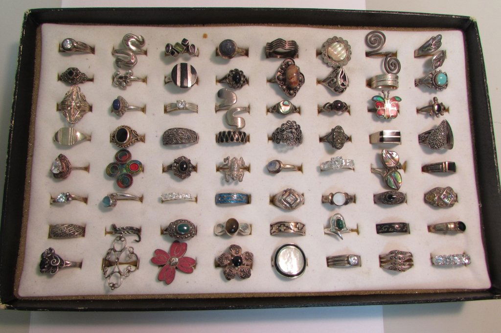 64 STERLING SILVER RINGS VARIOUS STONES: 2.0. LOT OF 64 STERLING SILVER RINGS. ONYX, TURQUOISE, CZ, LAPIS, MOONSTONE, MOP, ENAMEL, MALACHITE, MARCASITE PLUS OTHERS.