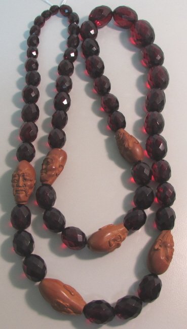 FACETED CHERRY AMBER NECKLACE CARVED FACE BEADS: 2.0 EXCELLENT DETAILED CARVED WOOD 29MM ASIAN CHINESE FACE BEADS, ALL DIFFERENT. MEASURES 40" LONG OVERALL. CHERRY AMBER BEADS 28MM BY 20MM TAPER TO 10MM BY 8MM.