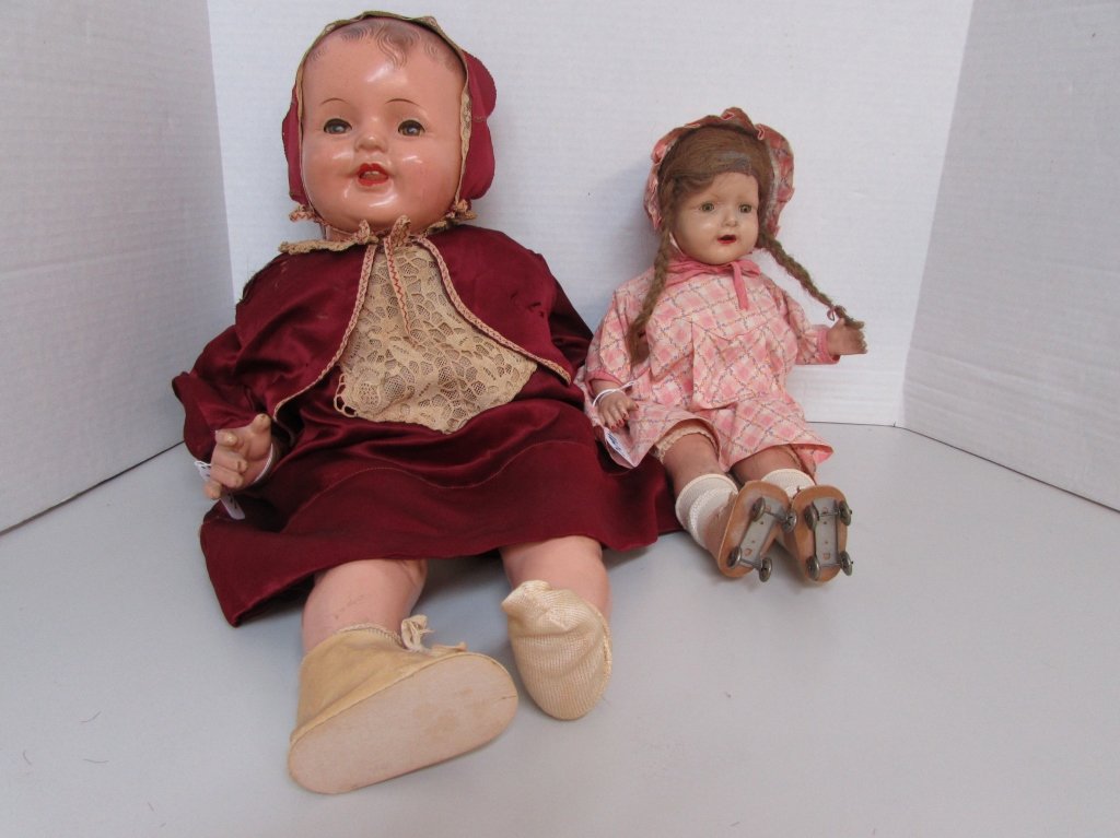 2 COMPOSITION & CLOTH BABY DOLLS ROLLER SKATES: BABY DOLL WITH PIG TAILS AND ROLLER SKATES 19" LONG. BABY DOLL WITH RED DRESS AND BONNET 26" LONG. THEY BOTH HAVE SLEEP EYES.