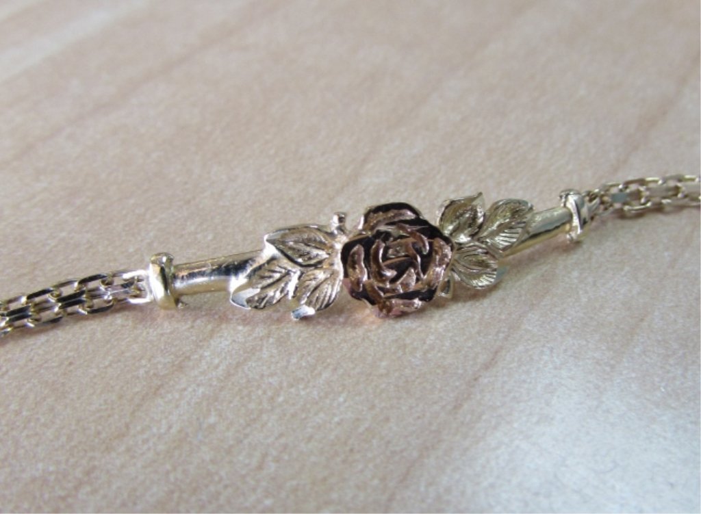 BISMARK LINK CHAIN & ROSE BRACELET 10K GOLD 7": 136.134. YELLOW GOLD WITH ROSE GOLD FLOWER. MEASURES 7 INCHES LONG . 2 GRAMS.