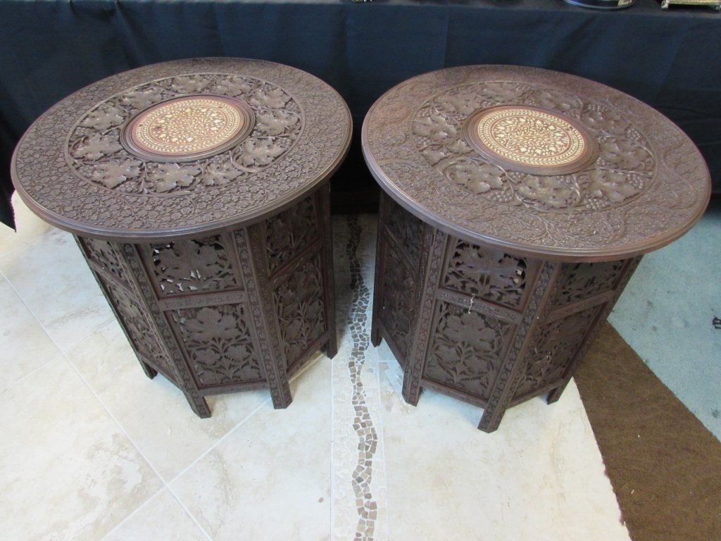 2 ASIAN CARVED WOOD SIDE TABLES INLAID BONE JAIPUR: PAIR OF HAND CARVED WOOD ACCENT TABLES w/ BONE INLAY. TOPS OF TABLES CAN BE REMOVED TO FOLD BASE FOR EASY STORAGE. 24.75" TALL, 24.25" WIDE. GOOD CONDITION, SOME NATURAL CRACKS IN WOOD & FEW BONE PIEC