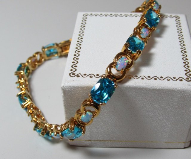 BRACELET STERLING SILVER BLUE TOPAZ OPAL SYNTHETIC: 8 1/4" 18K GOLD ON STERLING SILVER LINK CHAIN WITH 11 TWO CARAT BLUE AND .50CT OPAL TYPE STONES. 8 1/4" LONG, 20 GRAMS. NEW NEVER WORN, EXCELLENT CONDITION.