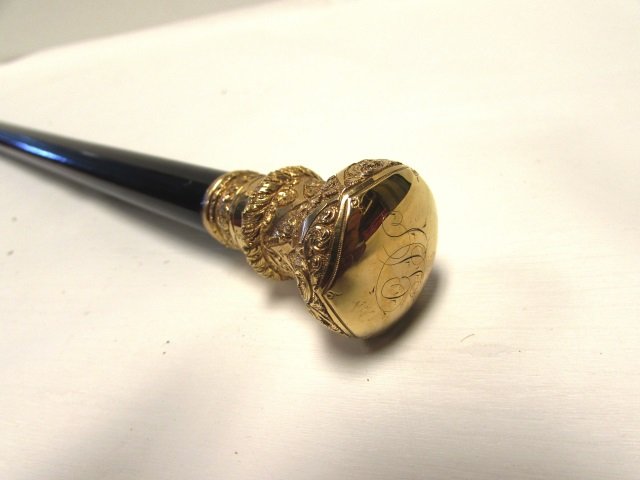 RFS WOOD GOLD CANE WALKING STICK IN SHEATH ANTIQUE: RFS & CO. EBONIZED WOOD CANE w/ ROLLED GOLD OVERLAY HANDLE. 33.75" TALL. INCLUDES PROTECTIVE CLOTH COVER.