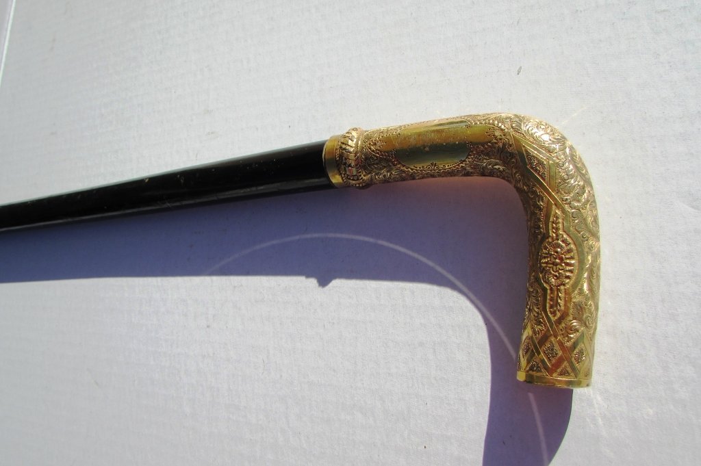 GOLD FILLED CANE EBONY WALKING STICK SWAGGER: EBONY COLORED WOOD WALKING CANE w/ 14 k ROLLED GOLD OVERLAY HANDLE. 35" TALL, 3.5" HANDLE. (SHIPPING FOR THIS ITEM IS $15).