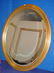 513: Gold tone oval beveled mirror.