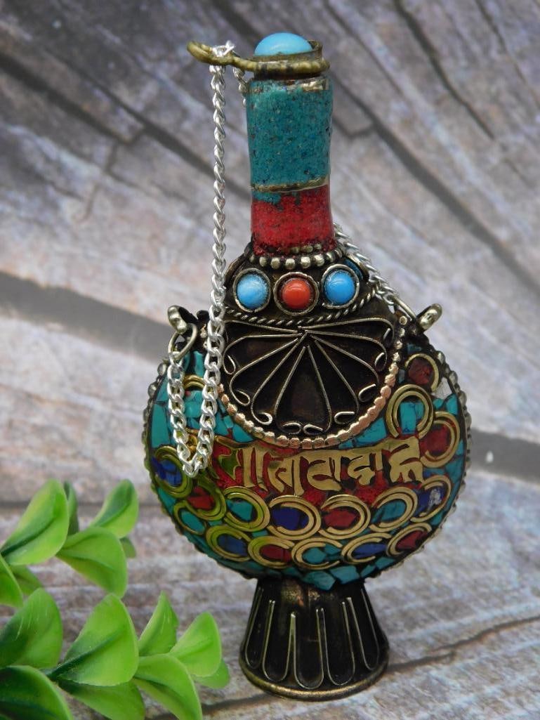 Enamel Decorated Metal Snuff Bottle with Chain and Stopper: This is a metal snuff bottle featuring colorful enamel decoration with intricate details. The bottle includes a chain attached to its stopper and displays ornate multi-colored designs, including red, 