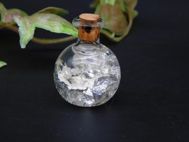 Glass Vial with Silver-Colored Mineral Fragments