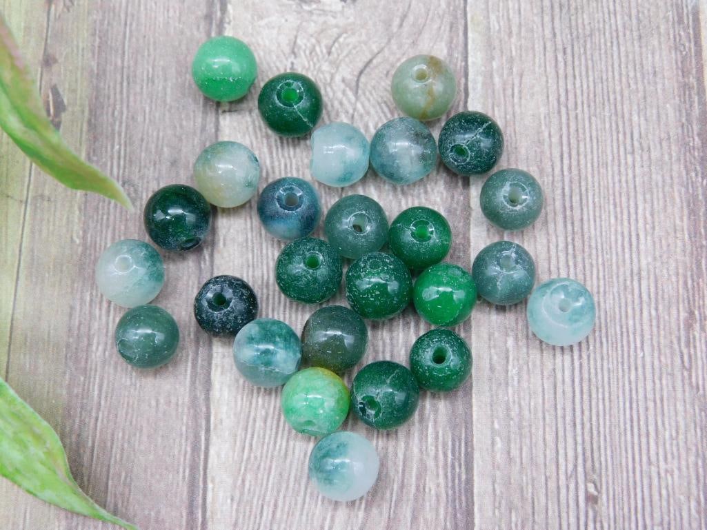 Lot of Assorted Green Stone Beads for Jewelry Making: A collection of assorted green stone beads ideal for jewelry making or crafting projects. Features a mix of shades ranging from light to dark green. Each bead is drilled, allowing for stringing or wir