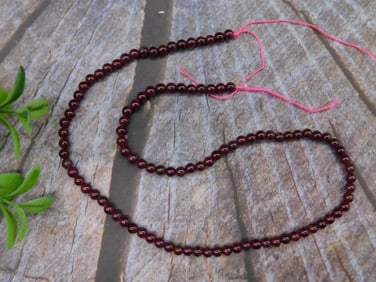 Strand of Round Garnet Beads with Pink Thread